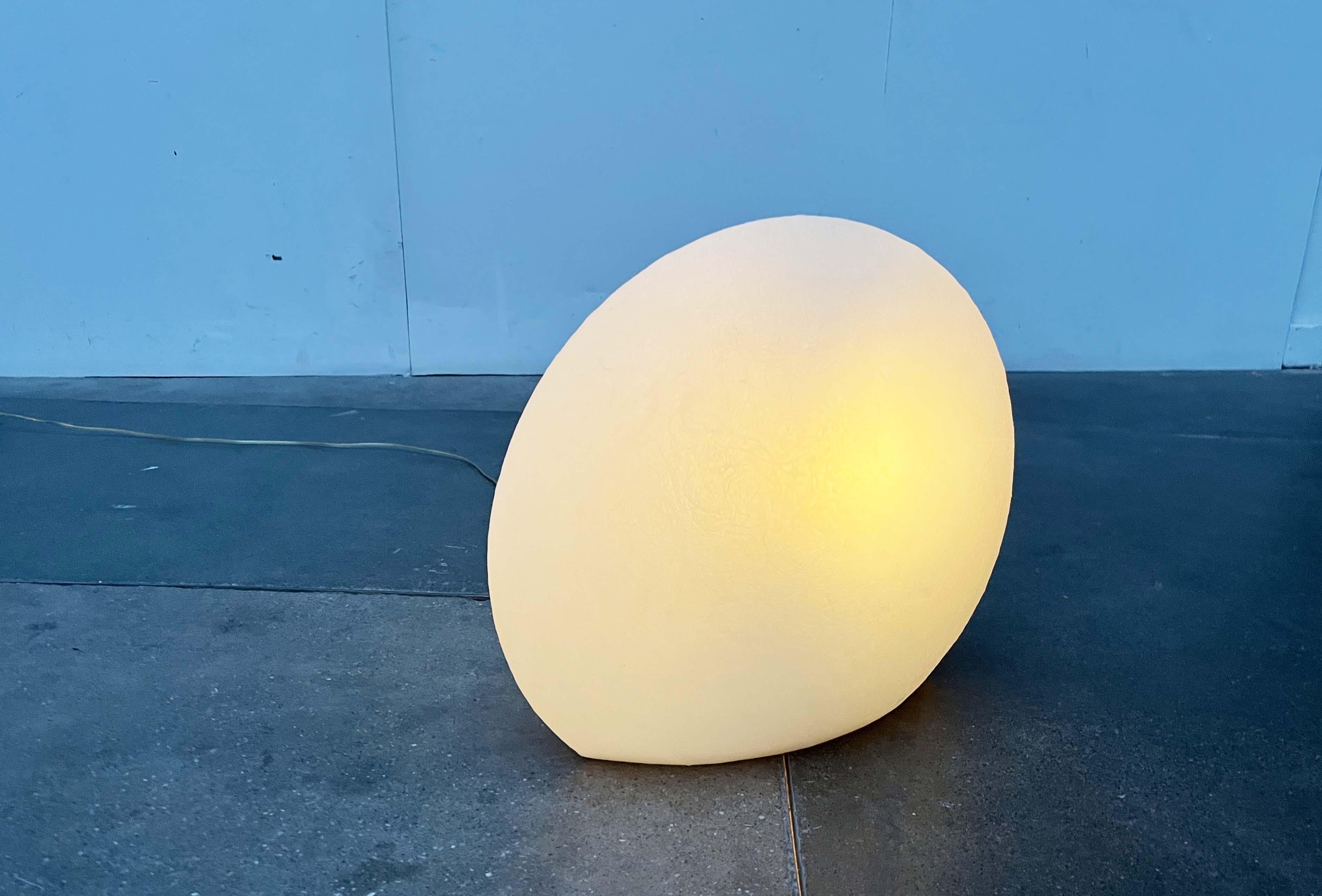 A design classic from Flötotto based on a design by Monika Lipken.

Simple and timeless floor lamp. The lens-shaped light fixture is made entirely of translucent plastic (PE). The surface has a texture reminiscent of fiberglass.
The lamp is in very