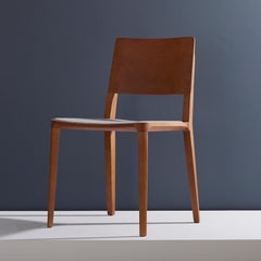 Sedia moderna minimalista in legno massiccio naturale con seduta imbottita in tessuto