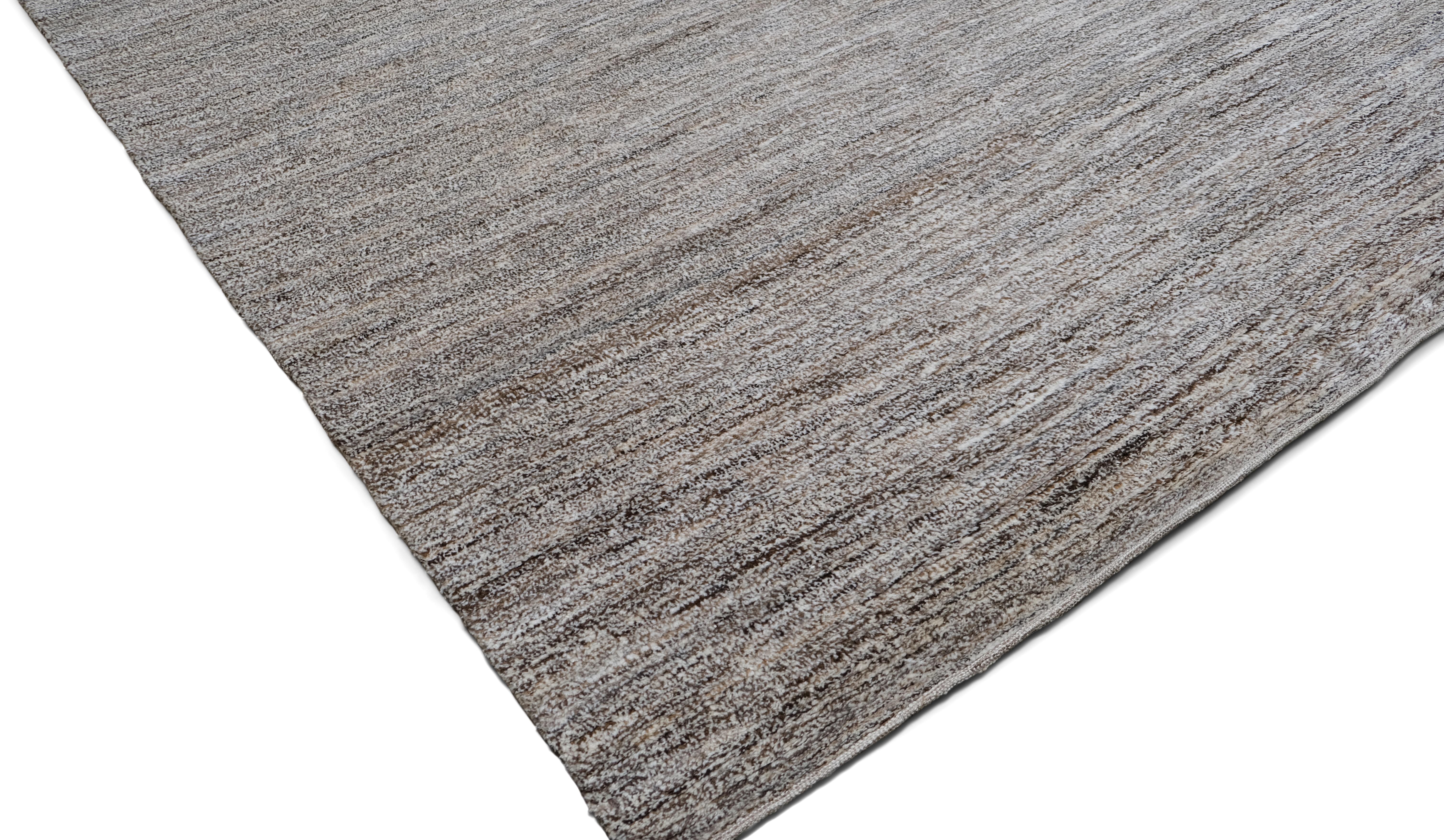 Dieser exquisite, handgeknüpfte Wollteppich verkörpert mit seinem minimalistischen, modernen Design unaufdringliche Eleganz. Die organischen Streifen in sanften Brauntönen erzeugen eine subtile Textur und verleihen dem Stück einen raffinierten und