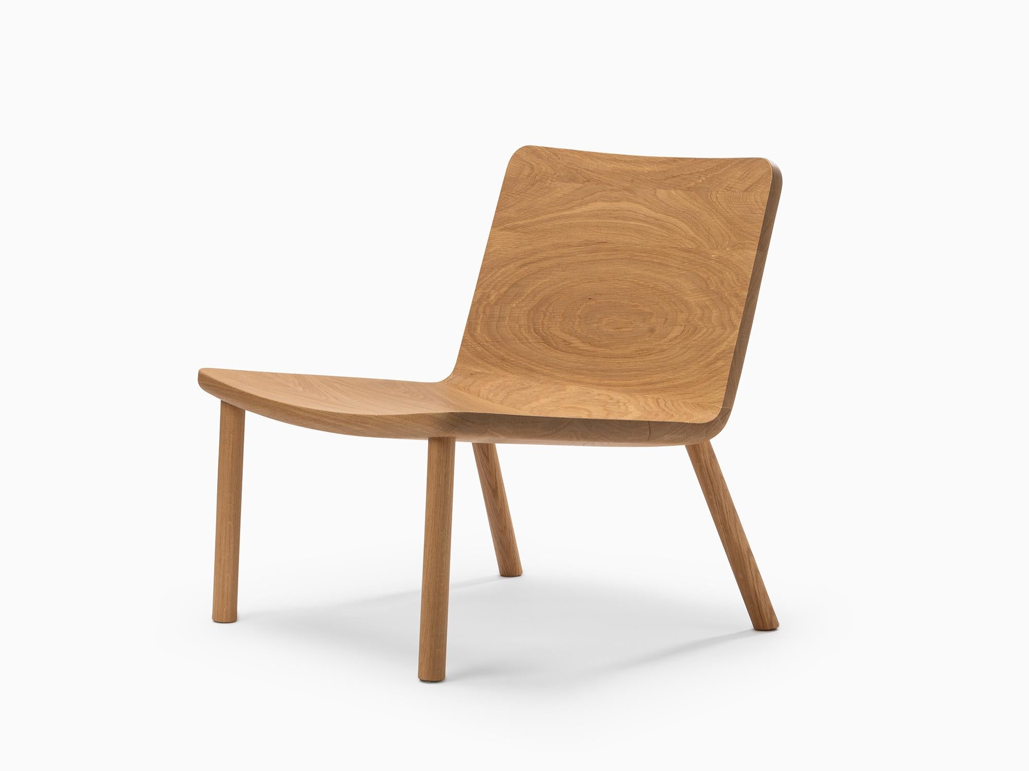 The Minimalist Modern Lounge Chair in Natural Oak - Allay is designed to bring simplicity, comfort, and functionality to any setting. Crafted from natural Oak wood, this chair showcases the organic beauty of its material while offering durability