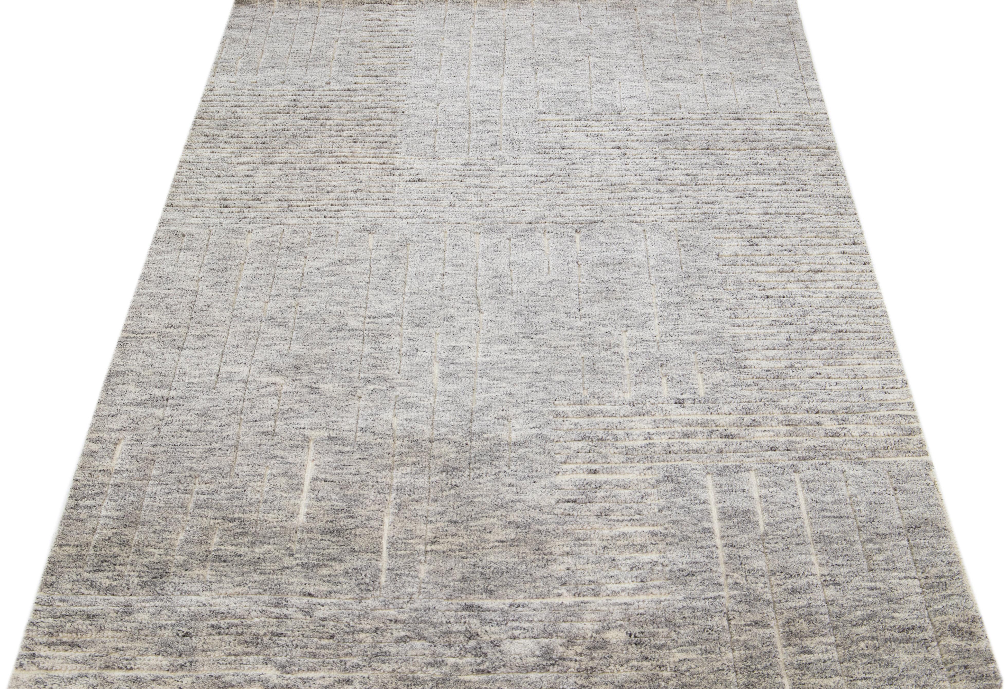 Beautiful modern Moroccan-style hand-knotted wool rug with a gray color field. This rug is part of our Apadana's Safi Collection and features a minimalist design in ivory.

This rug measures: 5' x 8'.

Our rugs are professional cleaning before