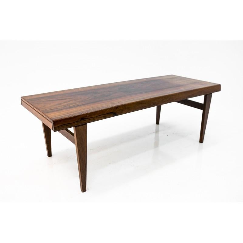 An elegant, rosewood coffee table from Denmark, from circa 1960s.
Minimal and simple form. 
Beautiful rosewood condition.
From both sides extensions one for hot drinks or plates and little shelf from the other.