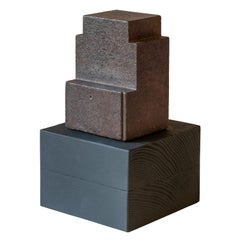 Minimalistische moderne Struktur, rostfarbener Stahl auf Holzblocksockel
