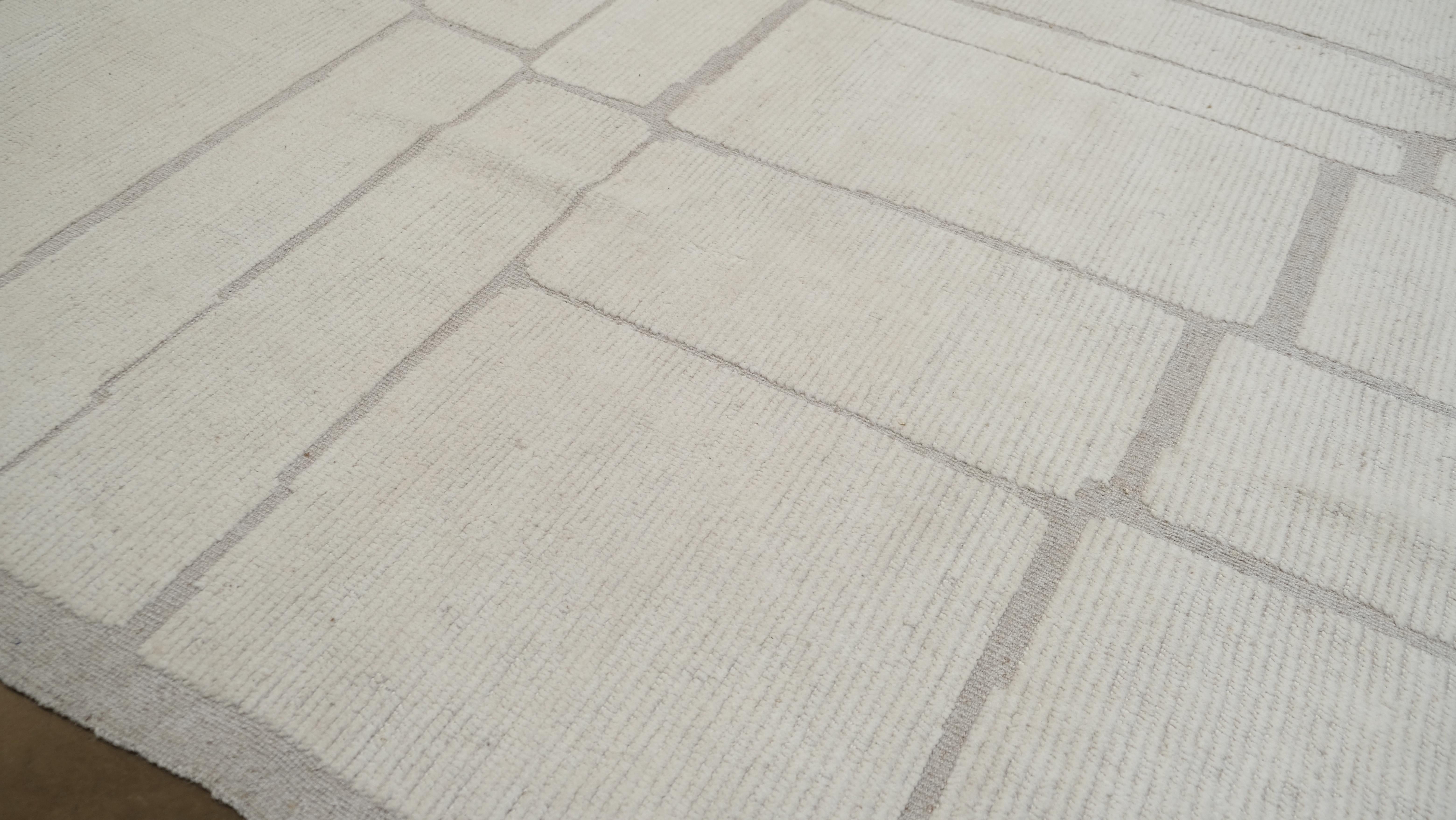 Dieser handgeknüpfte Wollteppich aus Pakistan wertet Ihren Wohnraum durch seine schlichte Eleganz auf. Mit seinem klaren und zeitgemäßen geradlinigen Design bietet dieser Teppich eine minimalistische Ästhetik, die perfekt zu modernen,