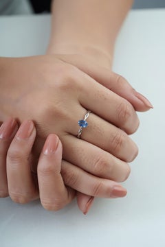 Anillo solitario minimalista con zafiro azul ovalado y banda retorcida en oro blanco de 14K
