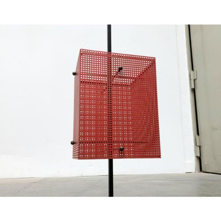 Minimalistischer Schildständer aus der Mitte des Jahrhunderts aus gelochtem Blech in Rot und Schwarz.

Kubische Formen und klare Linien durchziehen dieses Design. Vom Fuß über den Rahmen bis zur Quadratlochung des Blattes. Der perforierte Rahmen zur