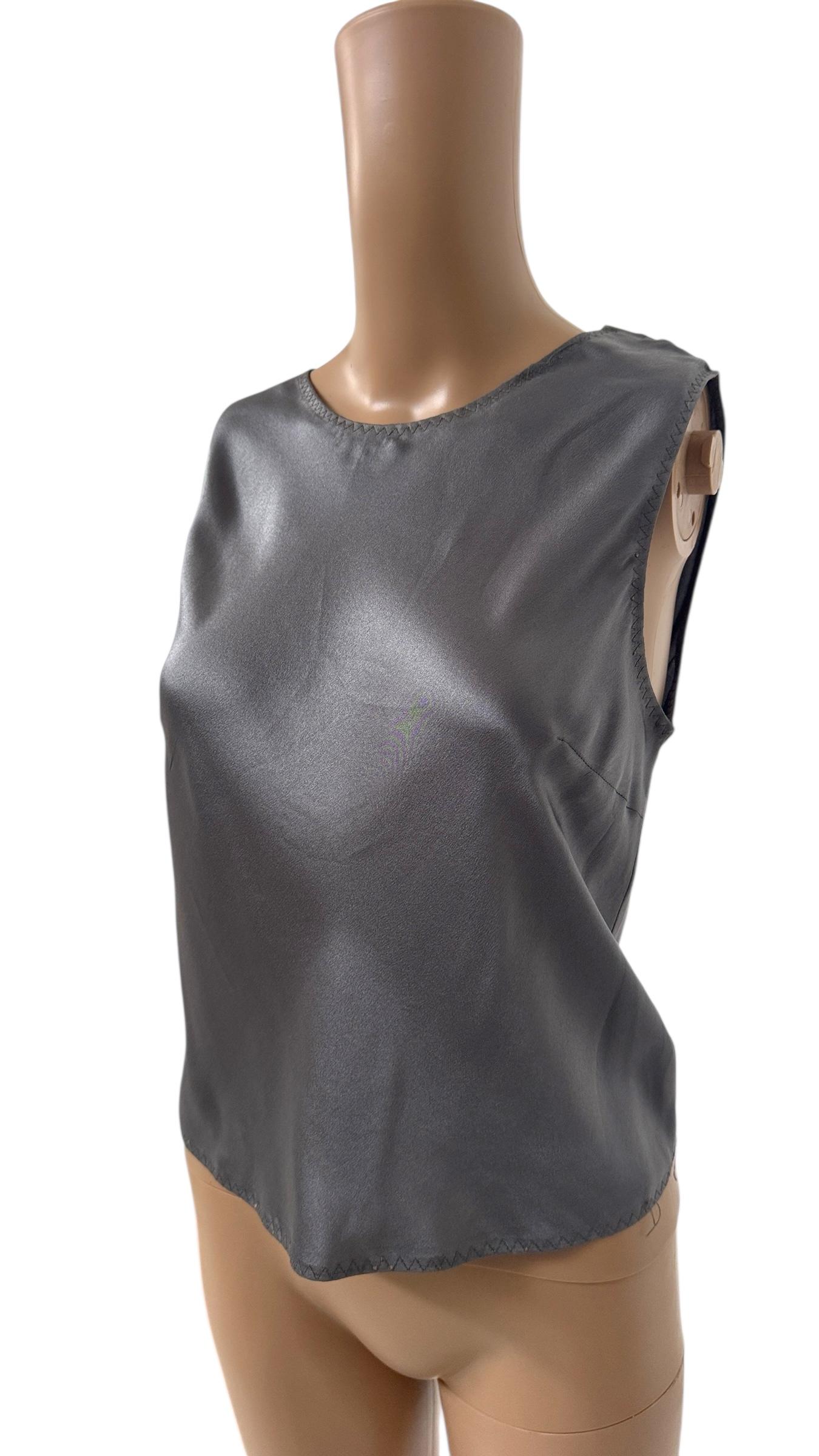 Effortlessly elegant and unmistakably Prada, this minimalist sleeveless top is crafted from pure silk in a refined shade of slate gray. The fluid silhouette is cut with clean lines and features subtle darts at the bust for a flattering fit. A fine