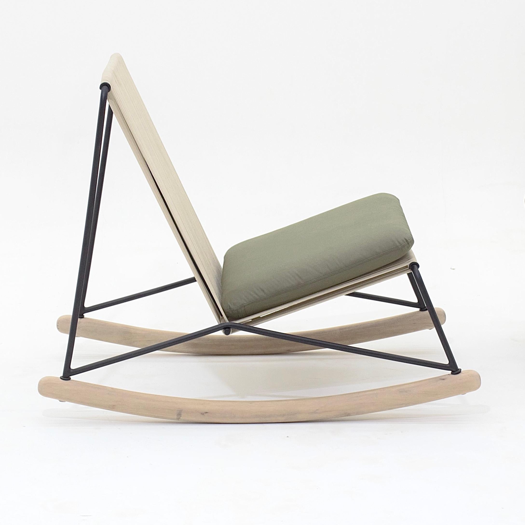 Ce fauteuil à bascule minimaliste en acier inoxydable, corde nautique, bois et tapisserie est conçu dans un raisonnement architectonique et géométrique. Tous les éléments constituent son fonctionnement et sont dimensionnés pour assurer la stabilité