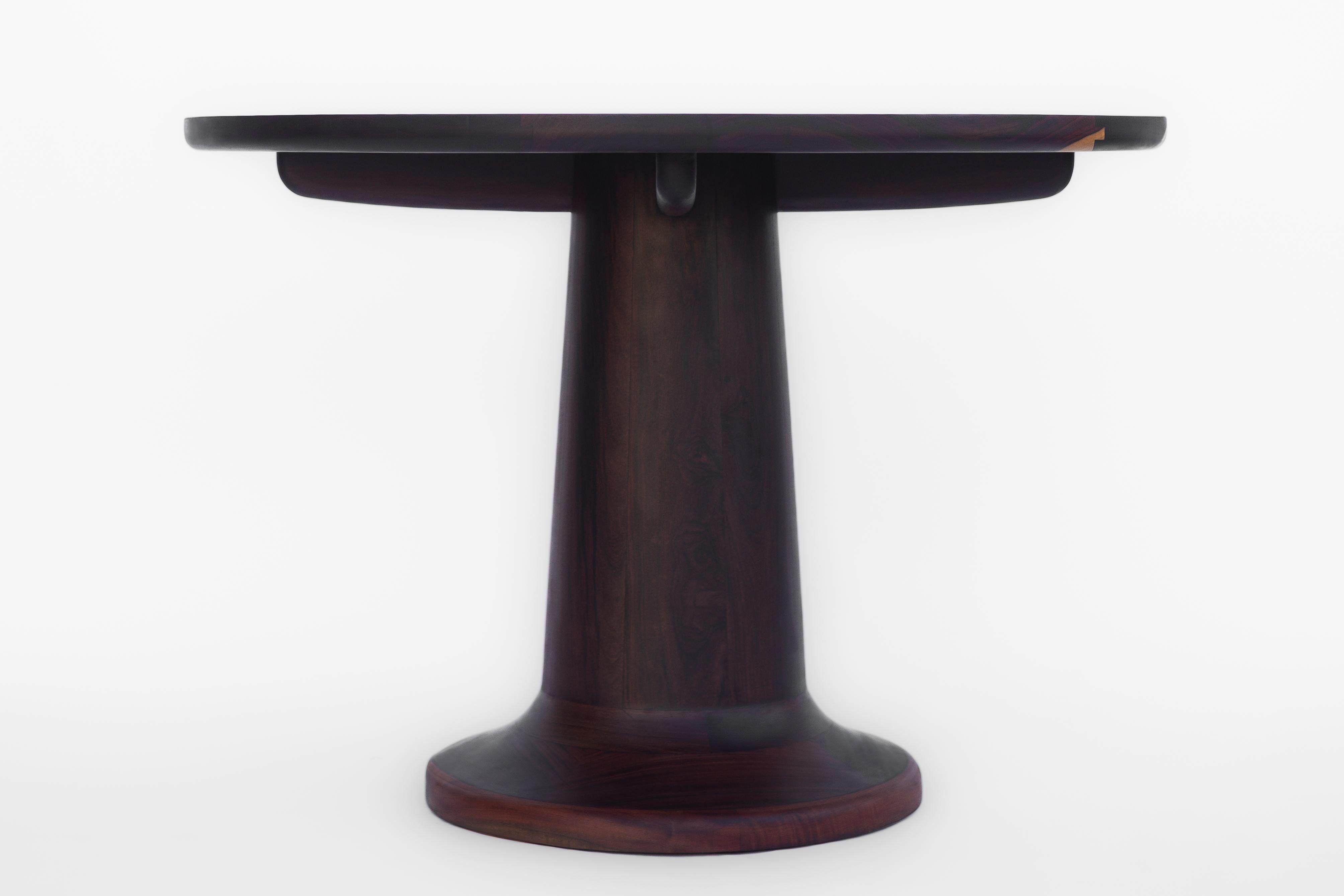Une pièce simple mais classique, fabriquée en bois Katalox - Mexican Ebony. Le ton naturel violet foncé du bois donne beaucoup de caractère à la table, tandis que ses formes incurvées lui confèrent du raffinement. Pour sa construction, nous