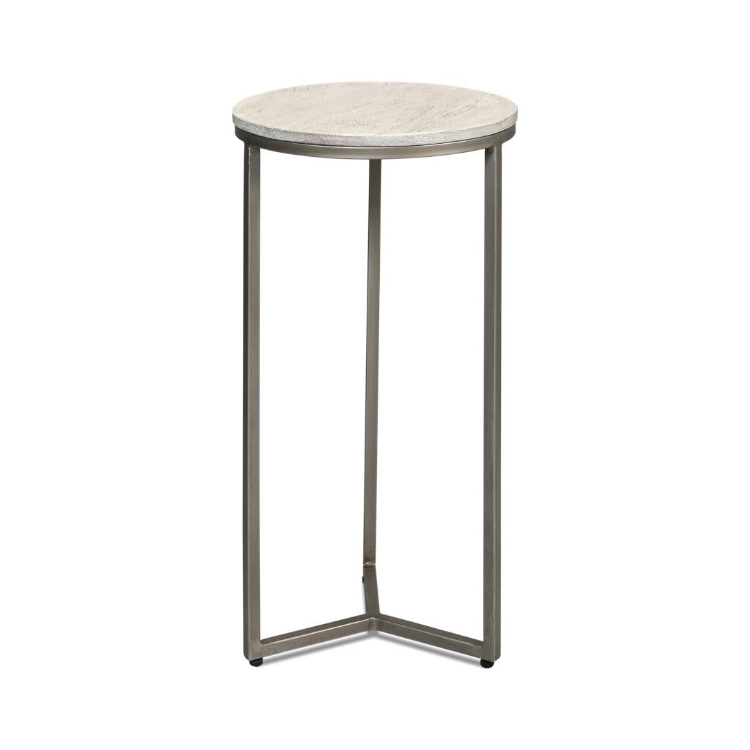With its grey-white round wooden top, this table captures the essence of urban design and complements any modern decor. The minimalist metal frame, finished in a matte gunmetal, forms a clean, open base that offers both support and an airy