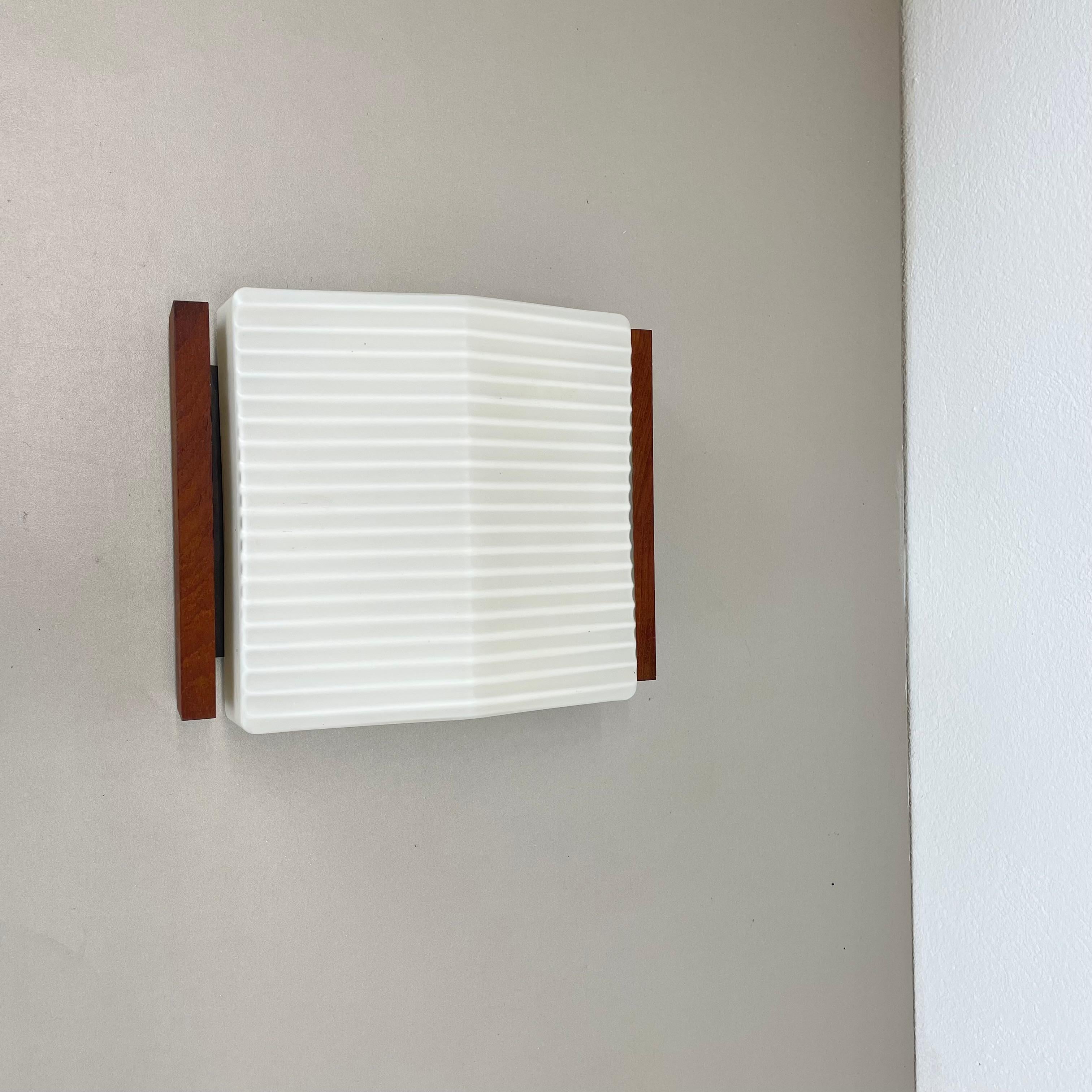 minimalist satin white glass and teak Wall Light by BEGA Lights, Germany 1960s In Good Condition For Sale In Kirchlengern, DE