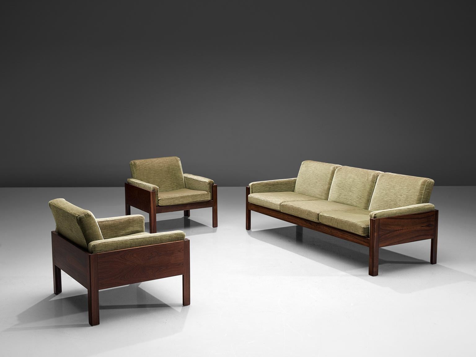 Living room set in rosewood and green fabric, Scandinavia 1960s.

This living room set consists of a three-seat sofa and matching set of lounge chairs in rosewood. The pieces have a Minimalist, modest and modern design. The sofa and chairs feature