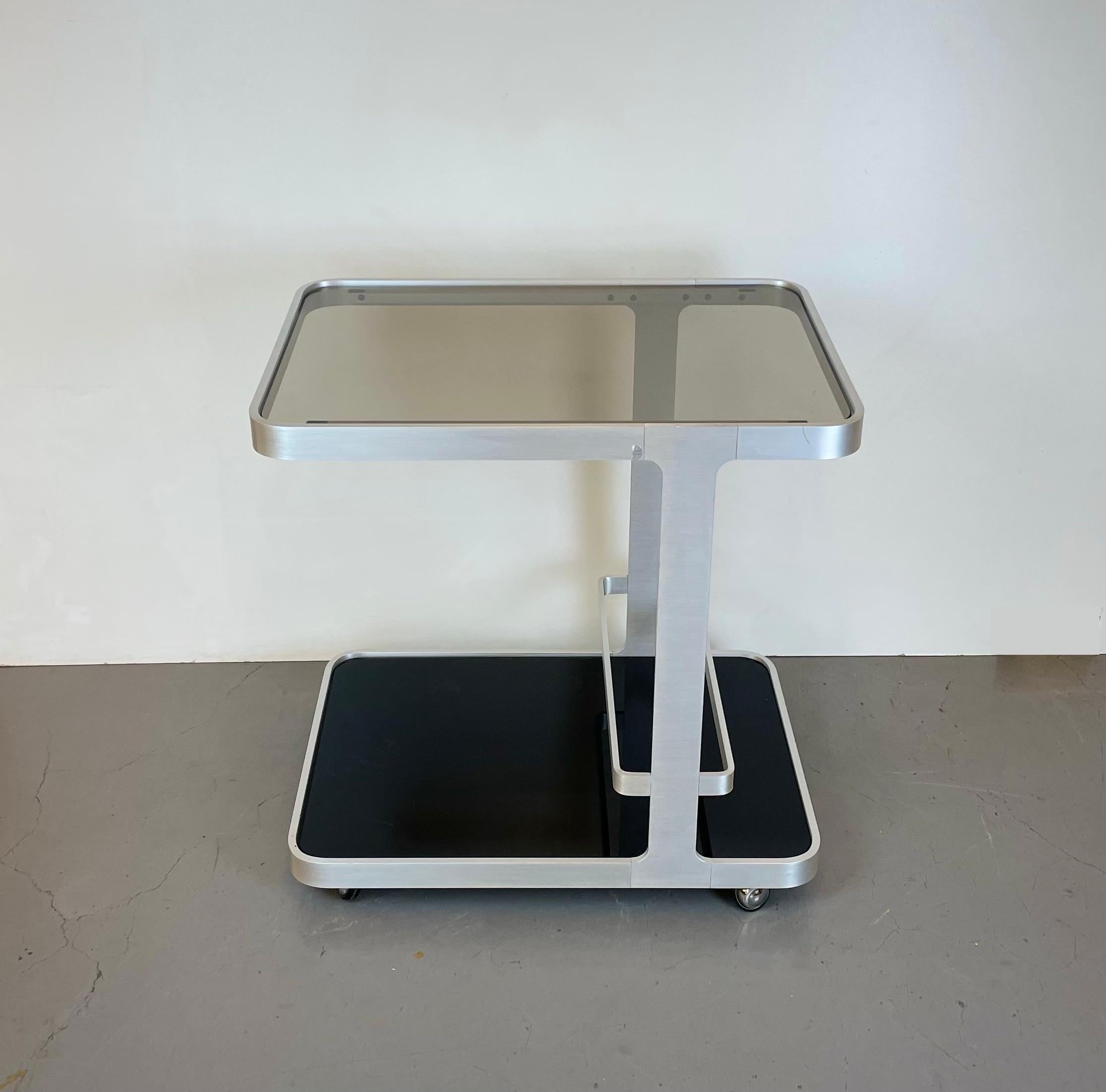 Rare French minimalist bar-cart in brushed aluminum with black and smoked glass designed by Pierre Vandal for the Espace Pierre Cardin in the 1970’s.
-
Rare chariot-bar minimaliste français en aluminium brossé avec verre noir et fumé conçu par