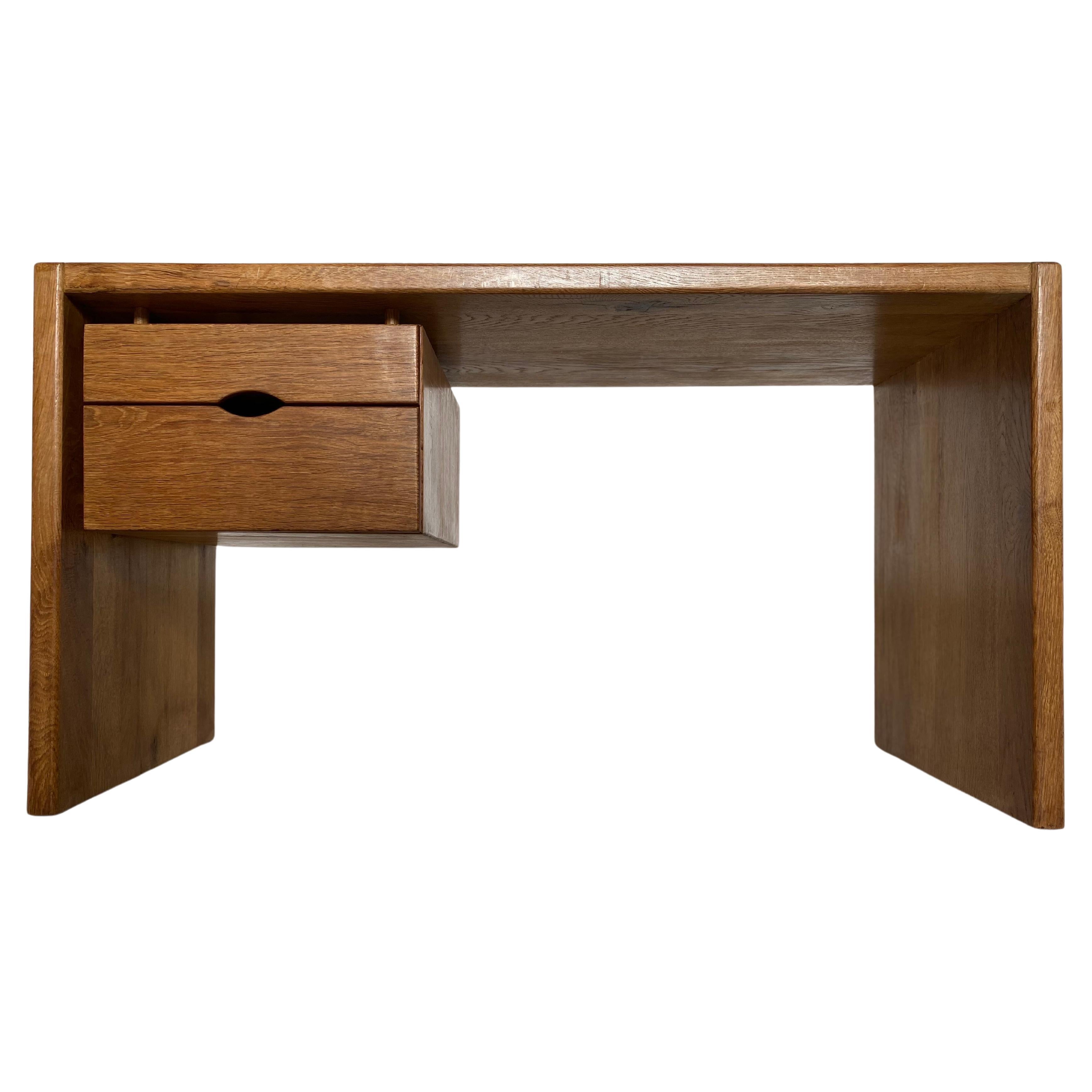 Minimalist dark stained oak desk with dovetail construction connecting the top to the side panels in solid oak with a floating part for 2 drawers. A beautiful piece of craftsmanship with a nice patina during the years.The desk is slightly lower in