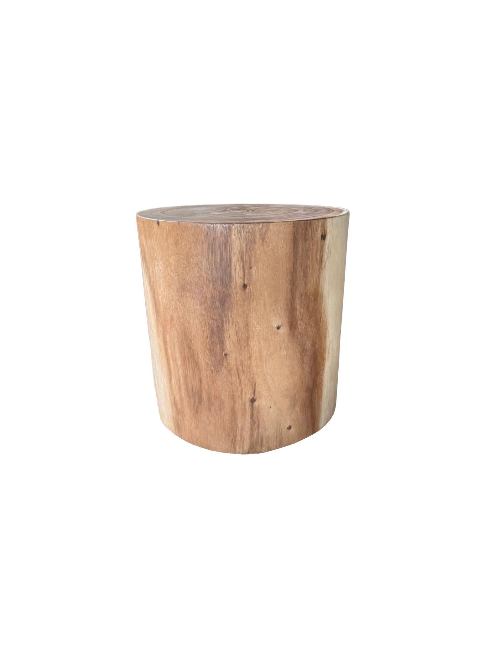Hand-crafted from solid mango wood, this sculptural side table embodies bold simplicity and artisanal character. Its tapered, drum-like silhouette highlights the natural grain and subtle textural variations of the wood, while the deep black burnt