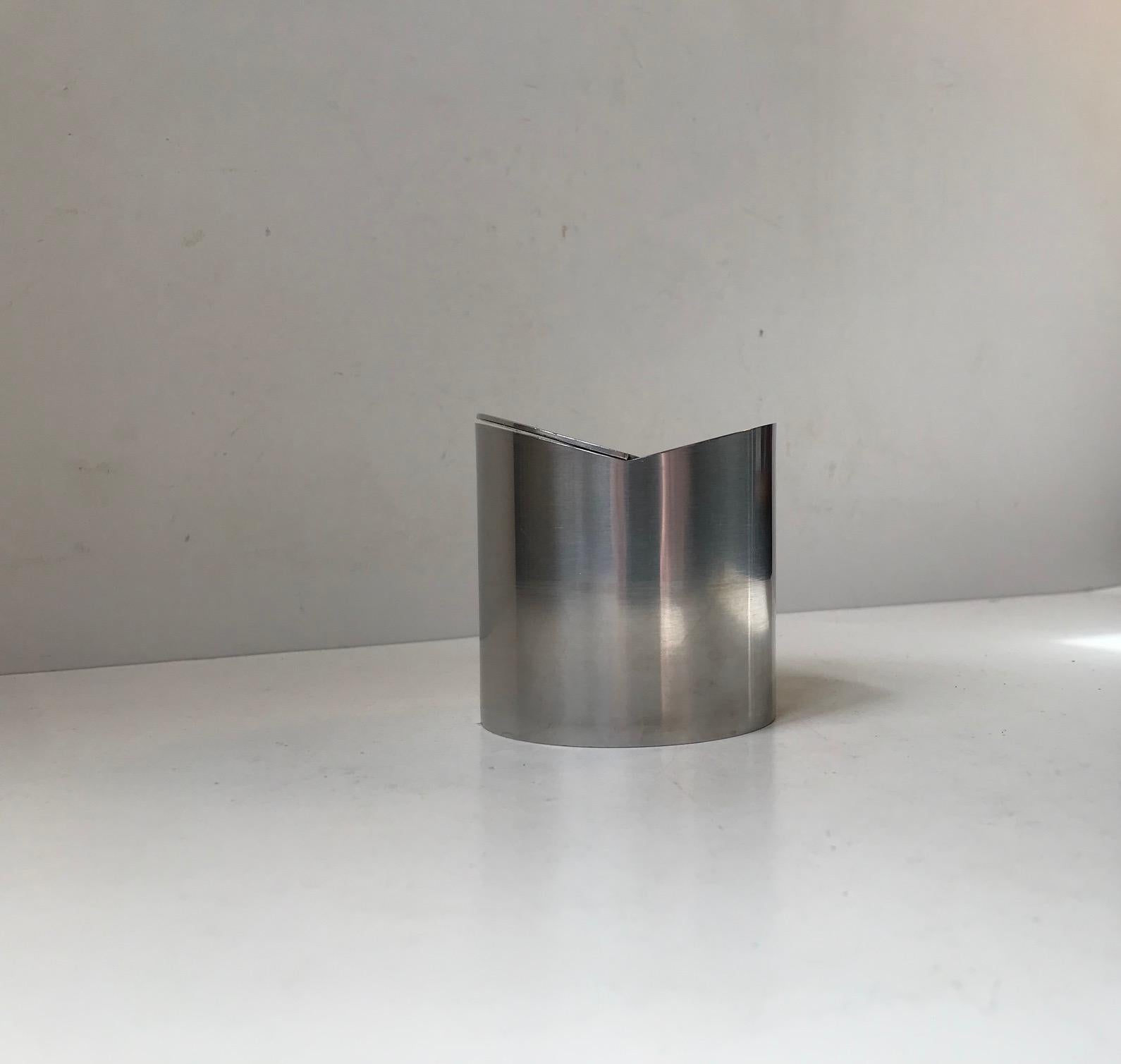 A stainless steel ashtray designed by Roelandt and manufactured by Stelton in Denmark during the 1980s. Similar to Arne Jacobsen's cylinda-line but with a tilting mechanism/lid instead. Imprinted with designer and makers marks beneath the base.