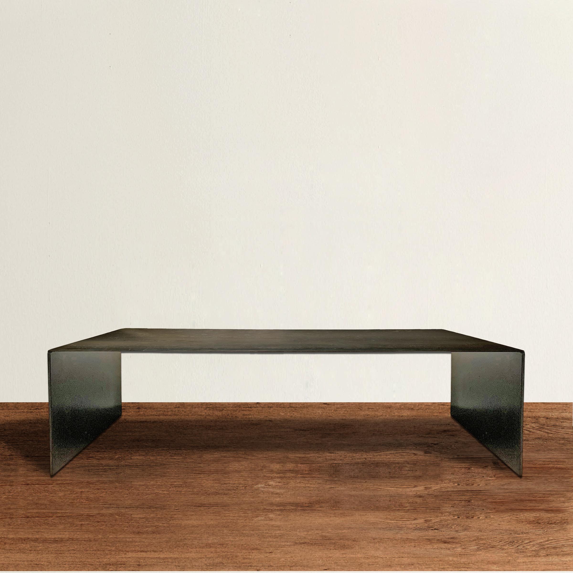 A strong and tenacious contemporary steel coffee table with a Brutalist's soul and a minimalist's attitude. Table is constructed of one piece of steel, with waterfall edges, and the finish is wonderfuly aged and distressed. Because of the