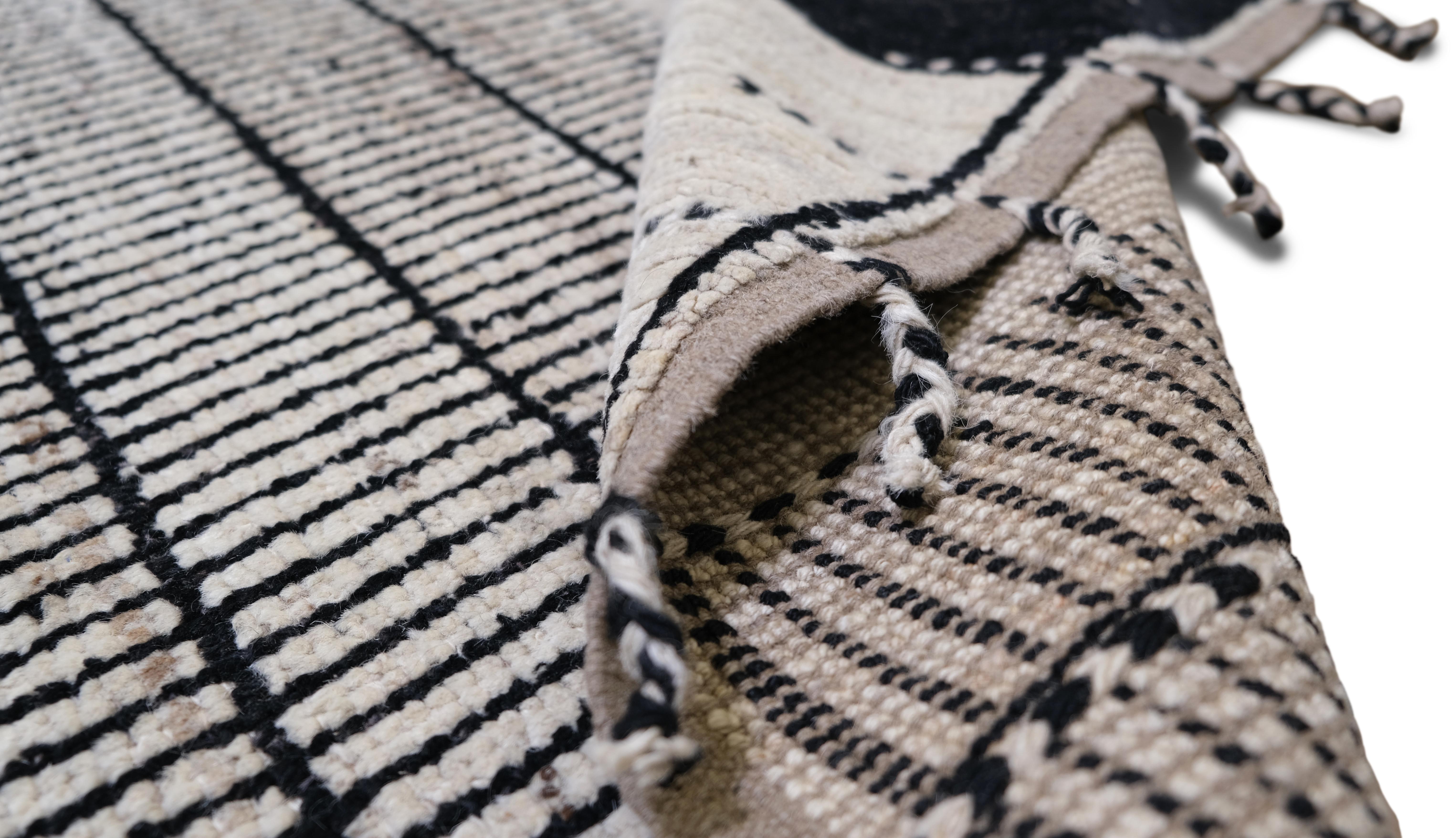 Elevate your interior with this striking modern hand-knotted wool rug. Featuring a minimalist geometric design, this rug combines intricate black and Ivory linear patterns with blue and black accent blocks, creating a dynamic visual statement. Its