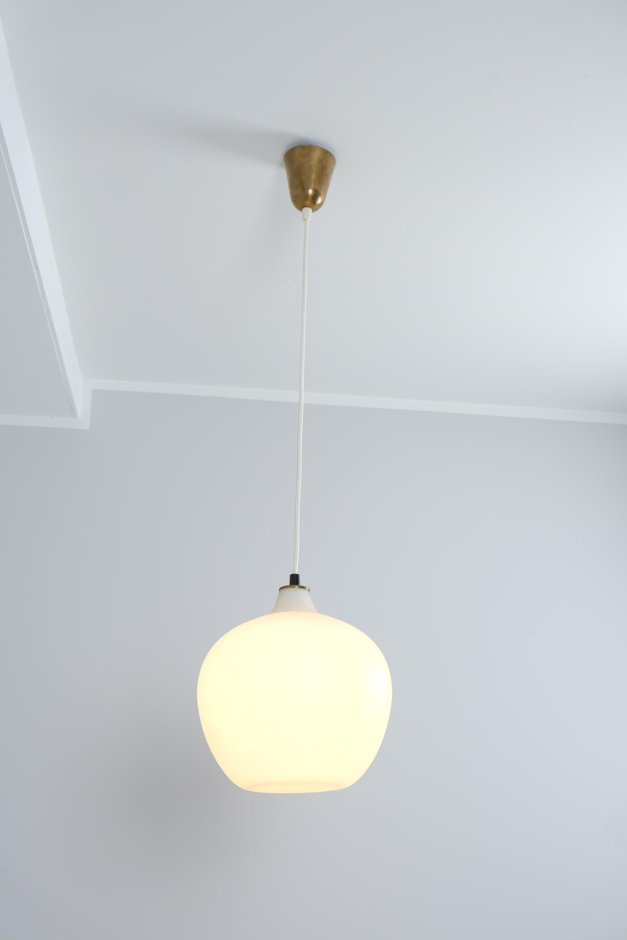 Un élégant plafonnier modèle. 51129 en verre opalin blanc, conçu par Tapio Wirkkala et fabriqué conjointement par Idman et Iittala en Finlande dans les années 1950. Ce design très minimal s'intègre facilement dans n'importe quel intérieur. Comme