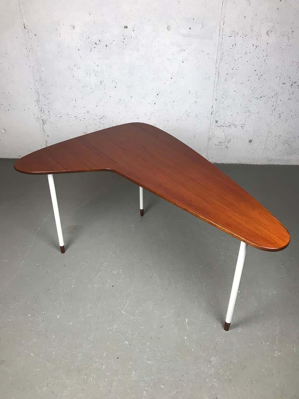 Minimalist boomerang shaped coffee or side table with a thick teak top and a walnut bottom. This piece shows many signs of quality construction. It has a thick teak top with walnut veneer underneath, as well as etched or routed grooves so the legs