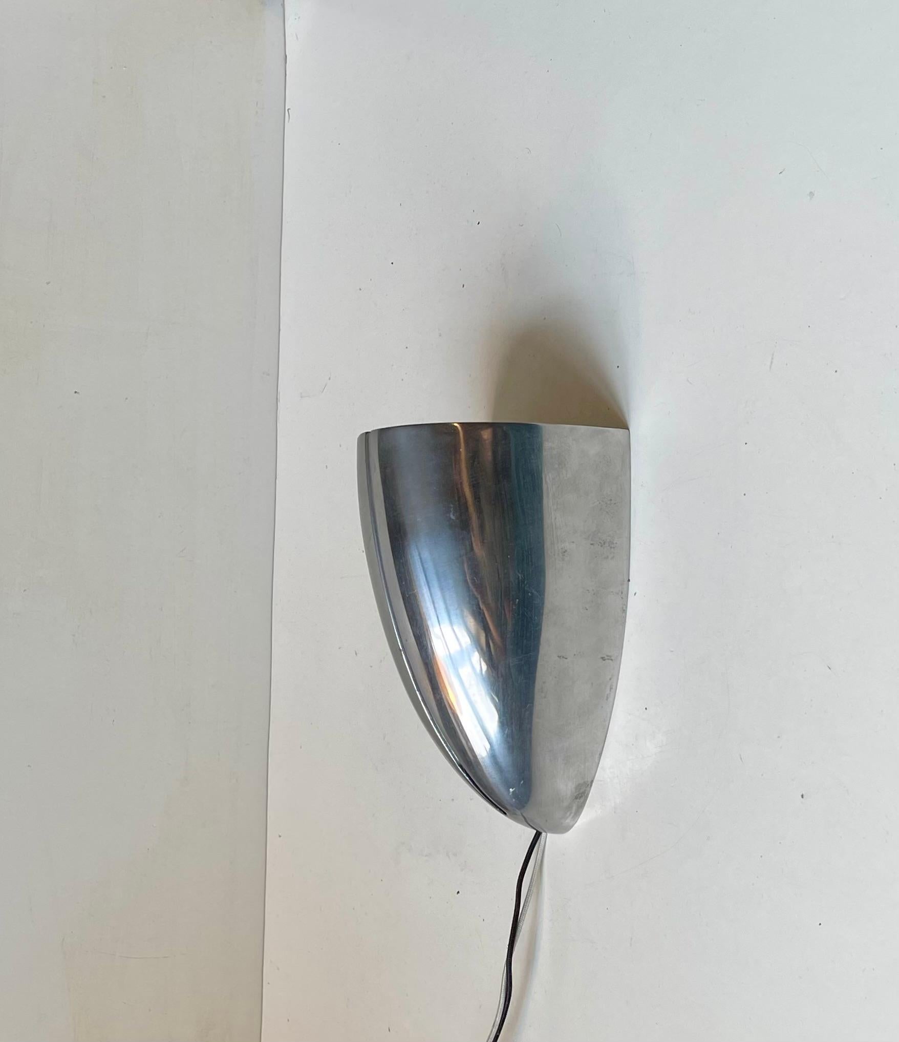 Hochwertige Up-Light-Wandleuchte aus poliertem Aluminium. In einem Stück gegossener Schirm mit vertikaler Teilperforation. Es wurde von ARTUP in den Vereinigten Staaten um 1970-80 entworfen und hergestellt. Sie kann relativ einfach auch zu einem