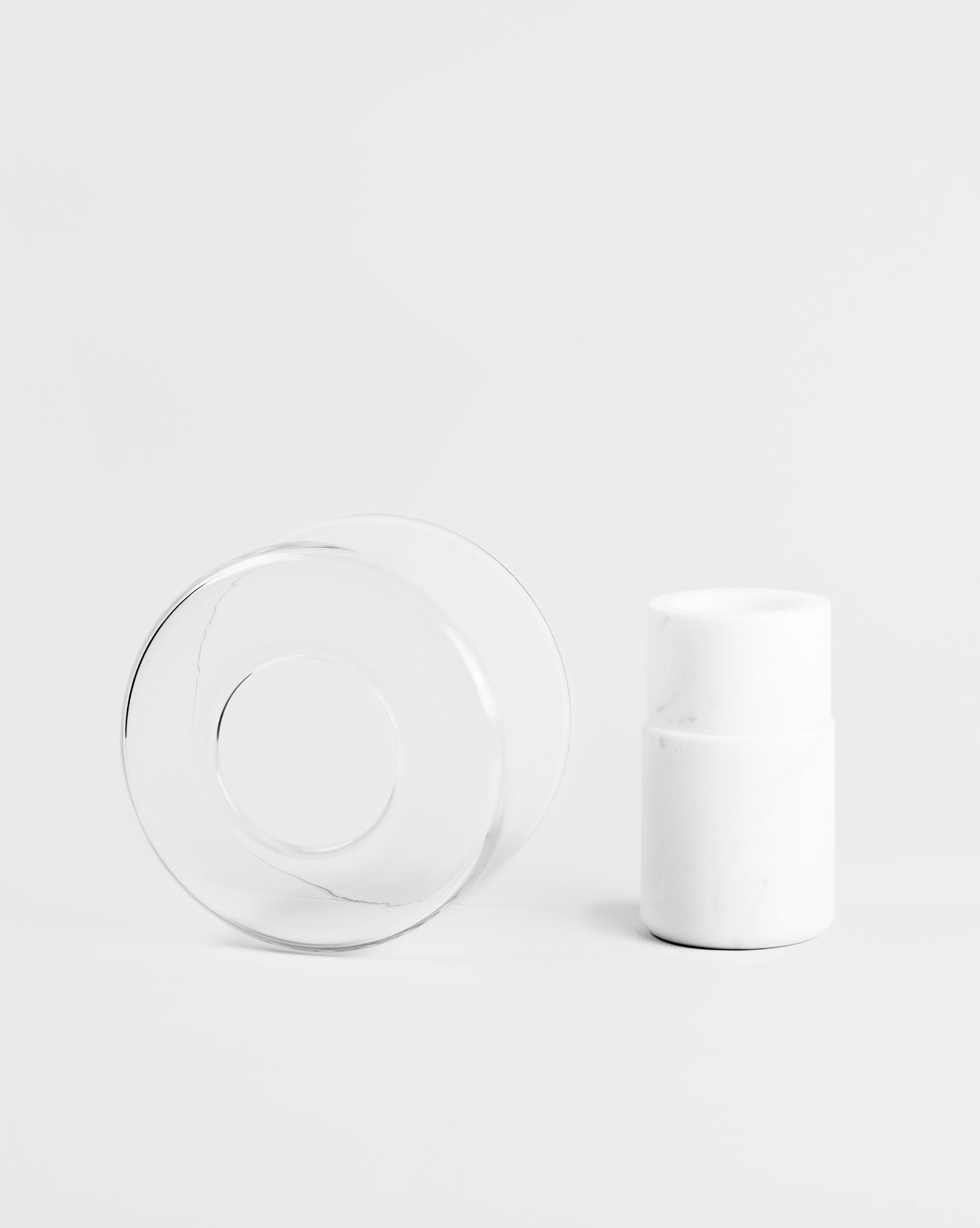 A glass and marble vase to add a touch of softness and detail to the interior. The thin and delicate material of the top contrasts the marble body of the base and creates a layered silhouette. The Italian word 