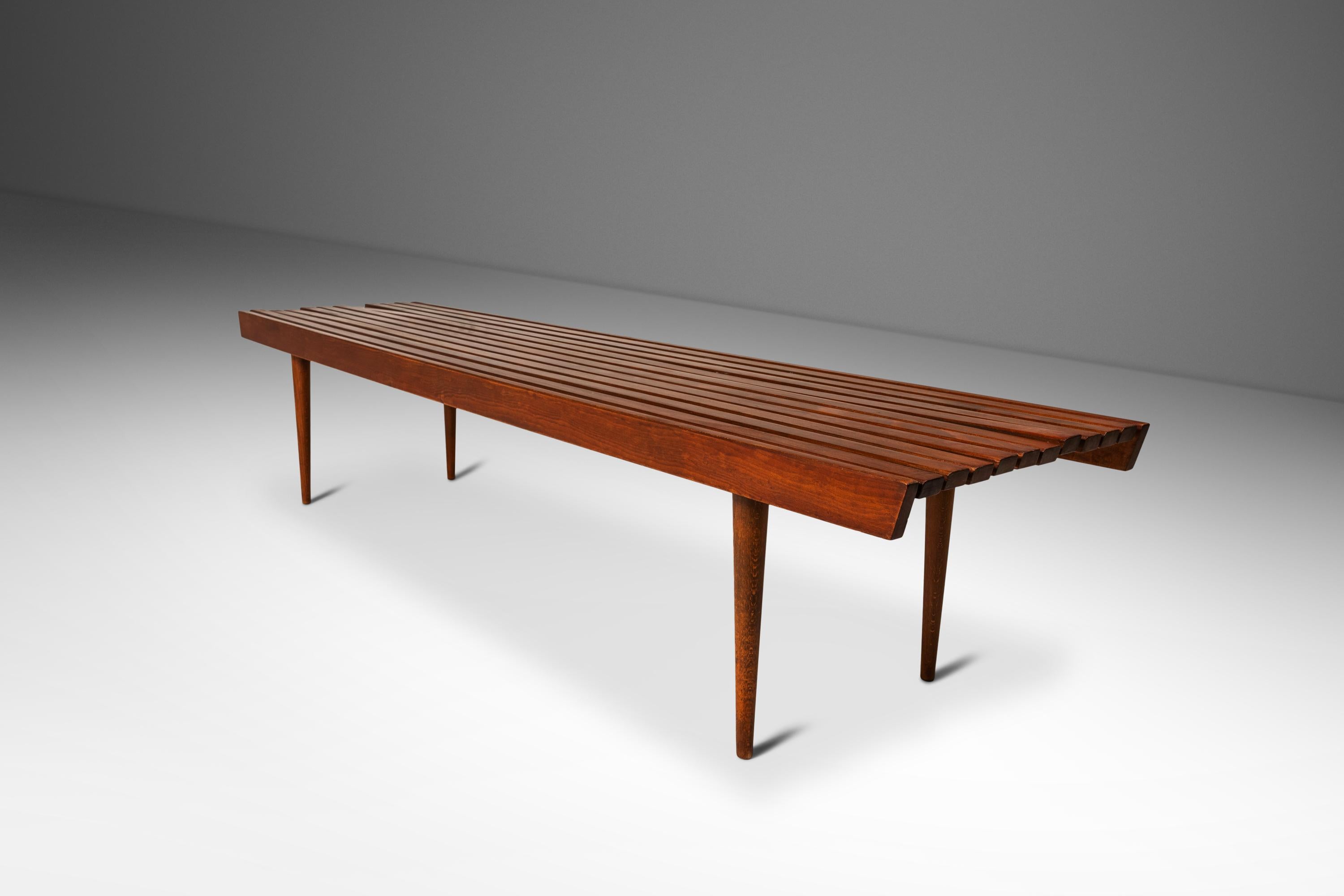 Introducing an iconic slatted minimalist bench made in Yugoslavia in the late 1950's. Constructed from solid bands of European walnut with exceptional woodgrains throughout this bench is the epitome of Mid-Century Minimalist design. Styled after