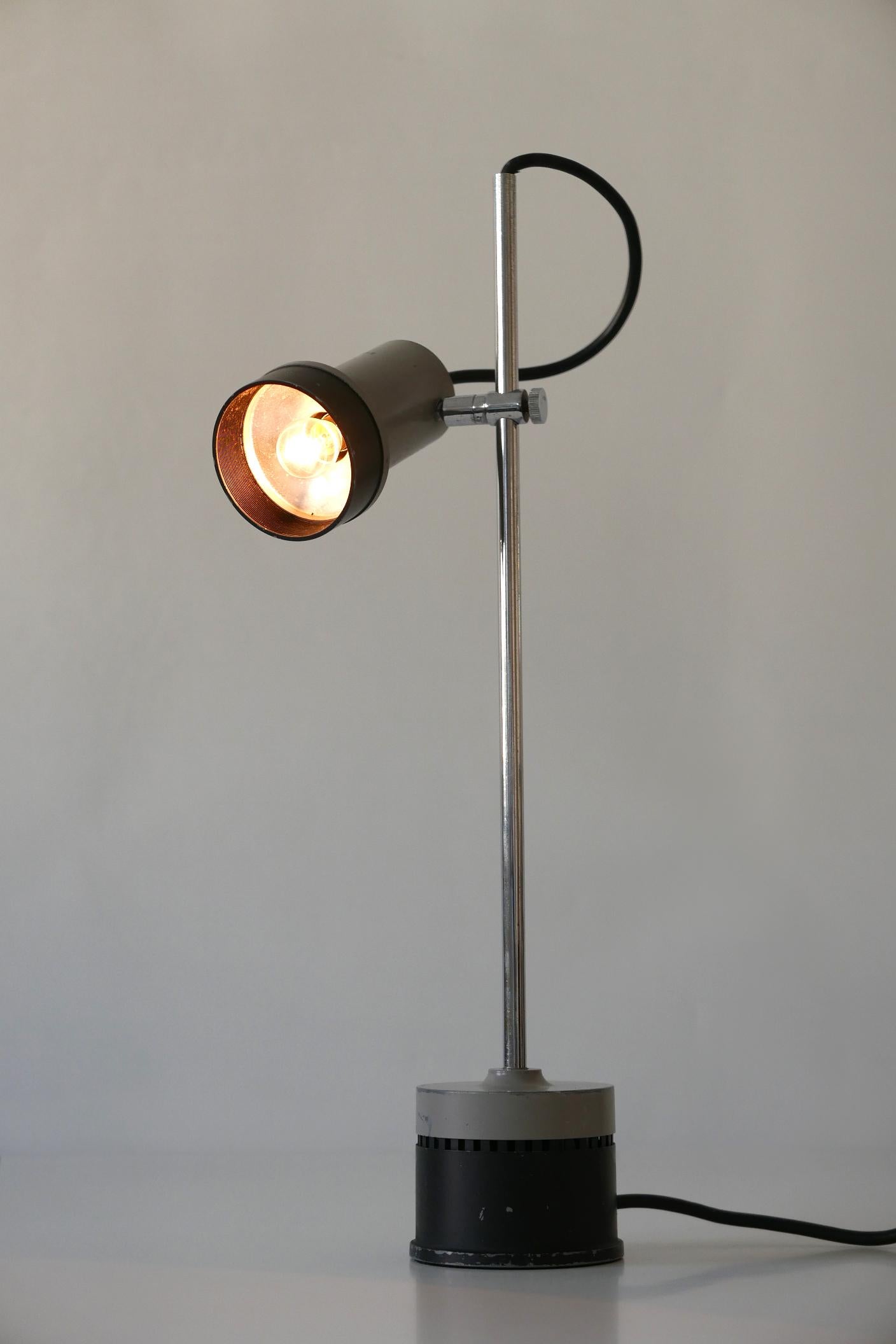Extremely rare, articulated Mid-Century Modern table lamp or desk light. Designed and manufactured probably in 1960s, Germany. Height and lamp shade adjustable in various position.

Executed in chrome-plated steel and black and gray enameled