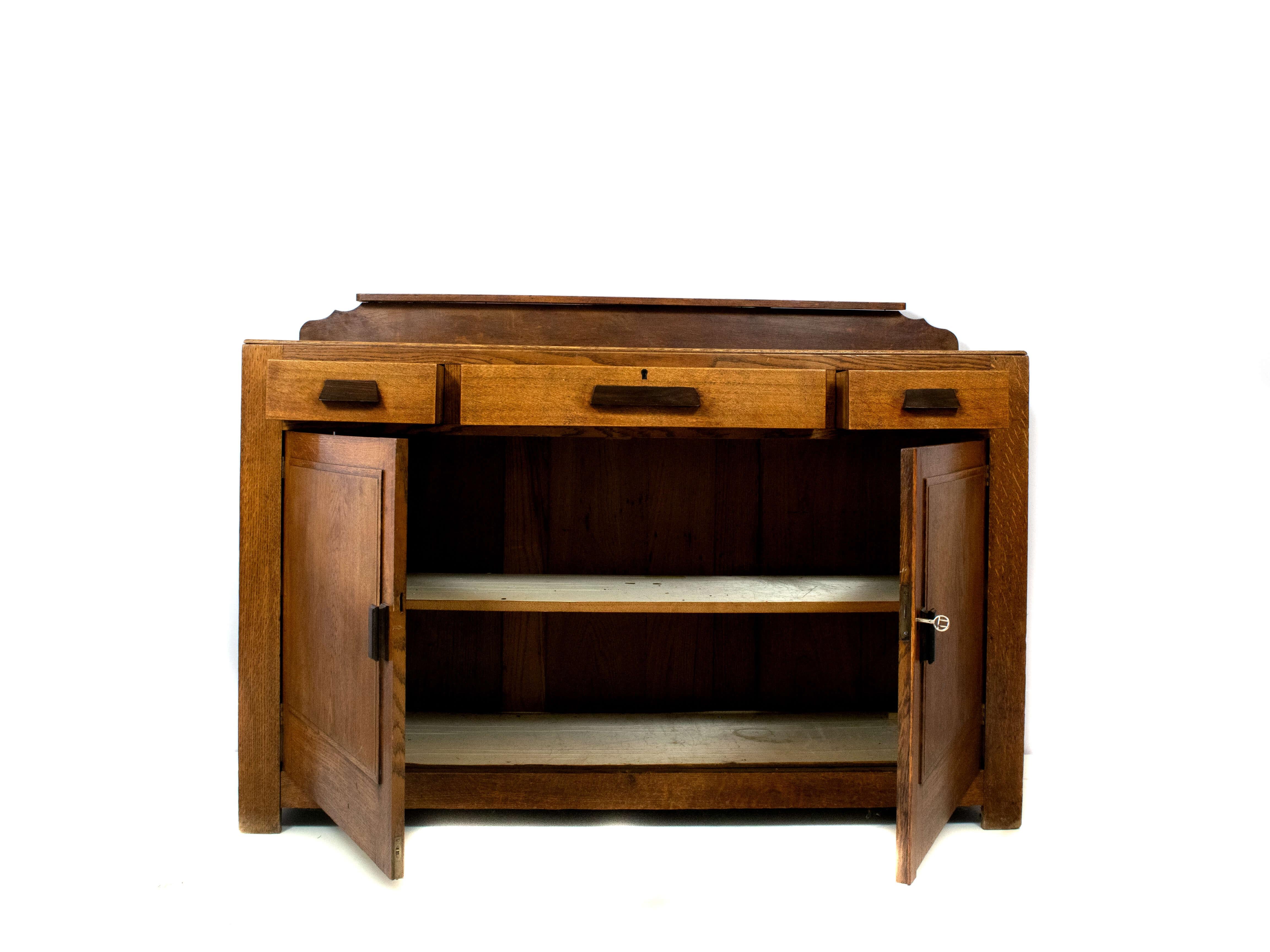 Minimalistic Amsterdam School dresser from the Netherlands, 1920s. This dresser in oak and coromandel handles is characterized by its simplicity and functionality. The craftsmanship is evident because of its solid construction and it has been made