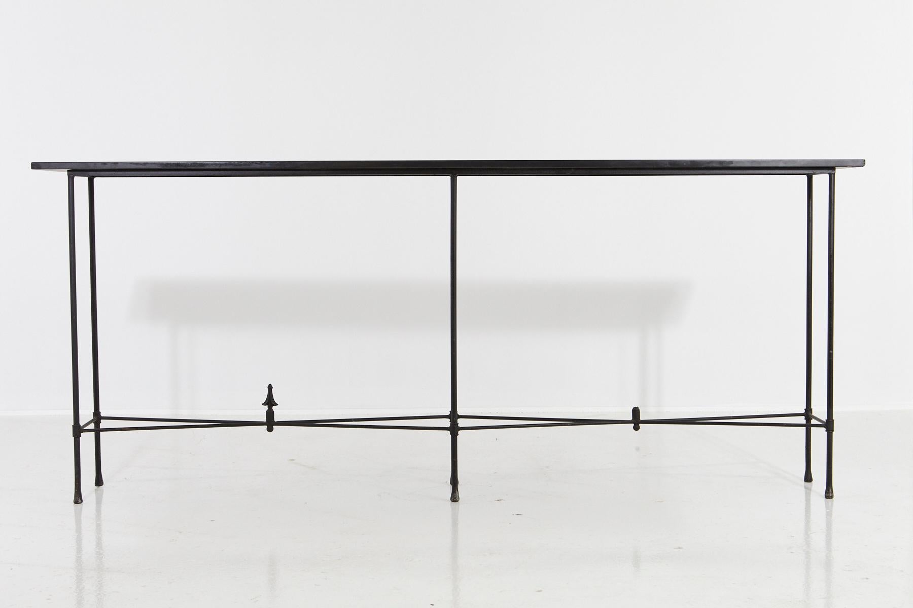 Minimalistic custom made, 7 ft. long wrought iron console with slate top, circa 1980s.
The console has a very, minimalistic, elegant appearance through its thin metal construction
and the narrow long piece of slate.
One of the finials is missing