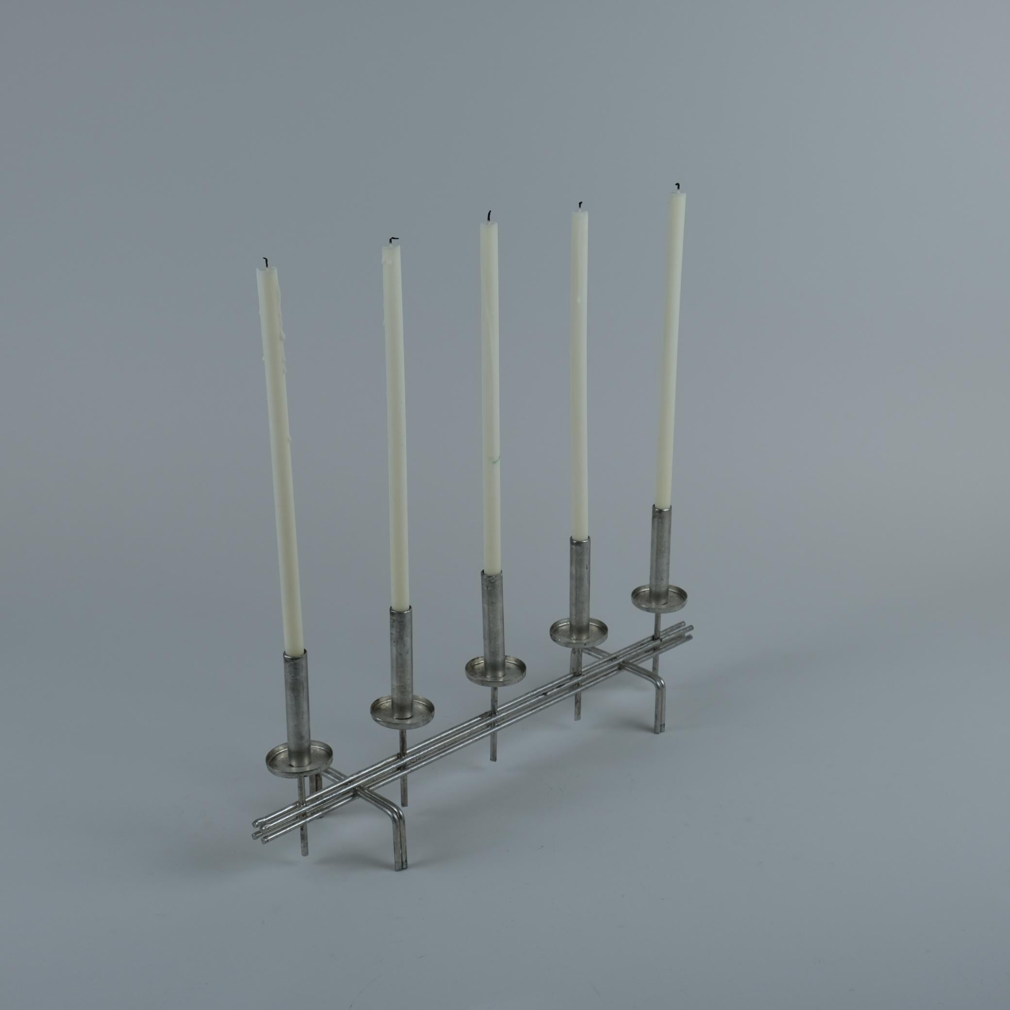 In addition to his iconic brass lamps, Paavo Tynell (1890-1973) designed candle holders and other metal items. This candle holder is such an example and was handmade late in his career by Paavo Tynell himself. After retiring from making lamps,