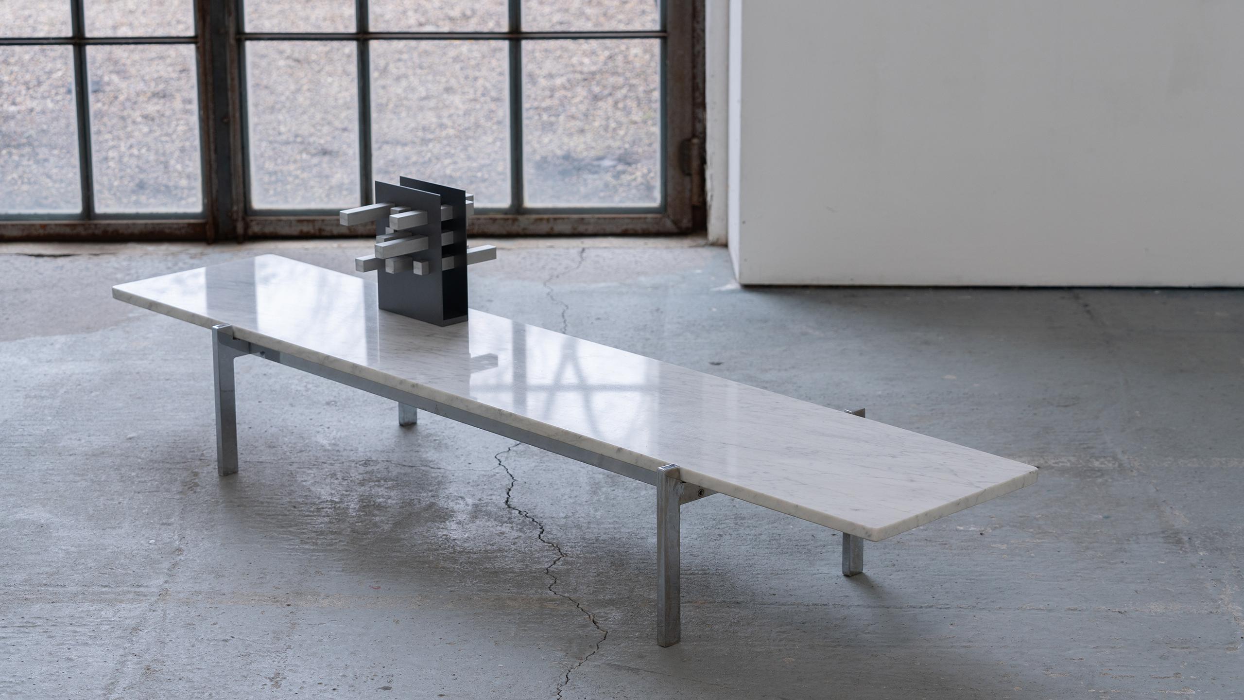 Very understated and minimalist low-table from the 60s coming from denmark.
2 materials - chrome-plated steel and marble, the tabletop is framed by the heights of the steel frame and is otherwise simply laid on top.

The plate as such measures