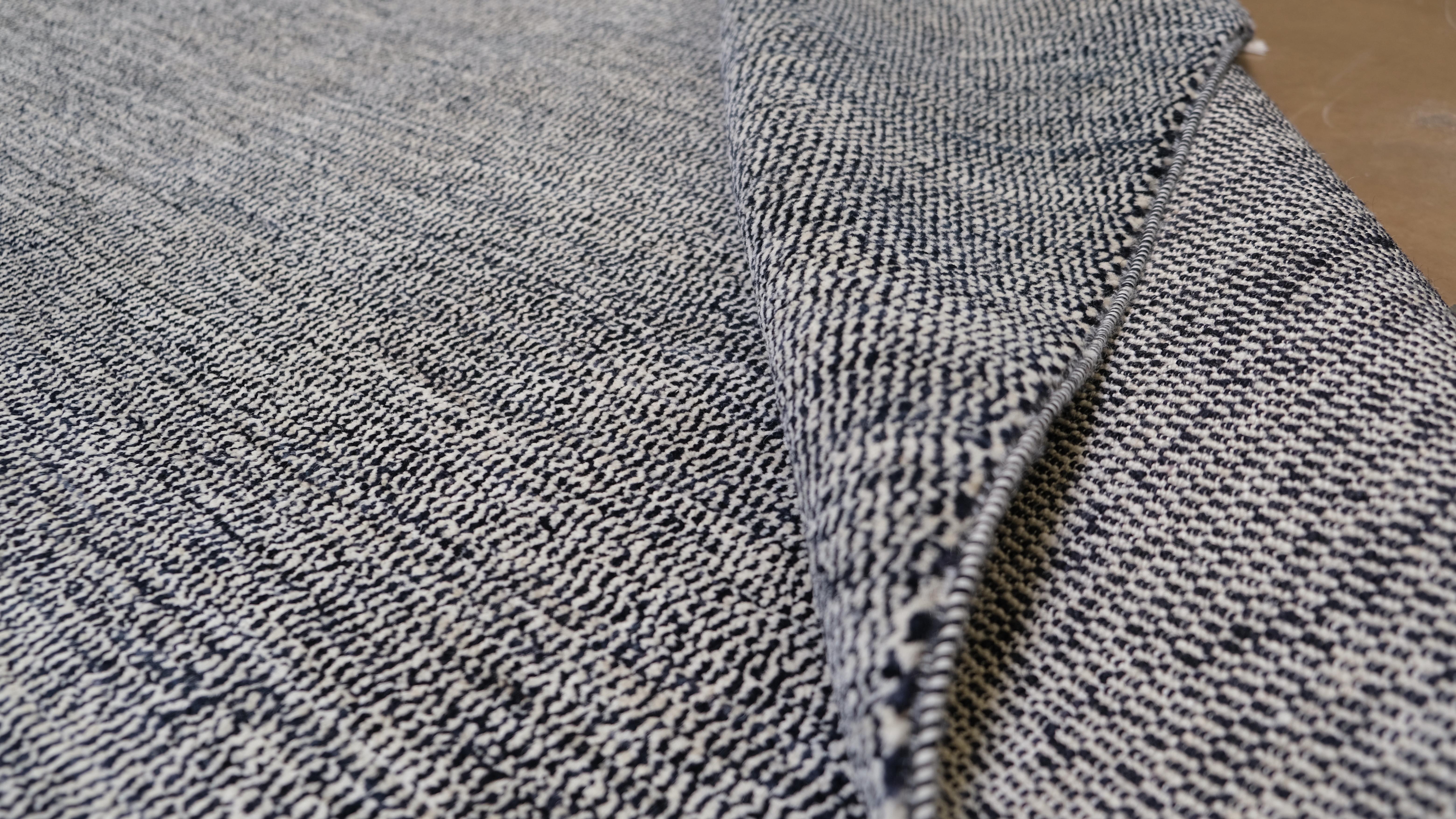 Dieser handgeknüpfte Wollteppich verleiht Ihrem Raum eine schlichte Eleganz. Mit seinen beruhigenden Schwarz- und Elfenbeintönen schafft dieser minimalistische Teppich eine ruhige Grundlage für moderne, zeitgenössische oder übergangsweise