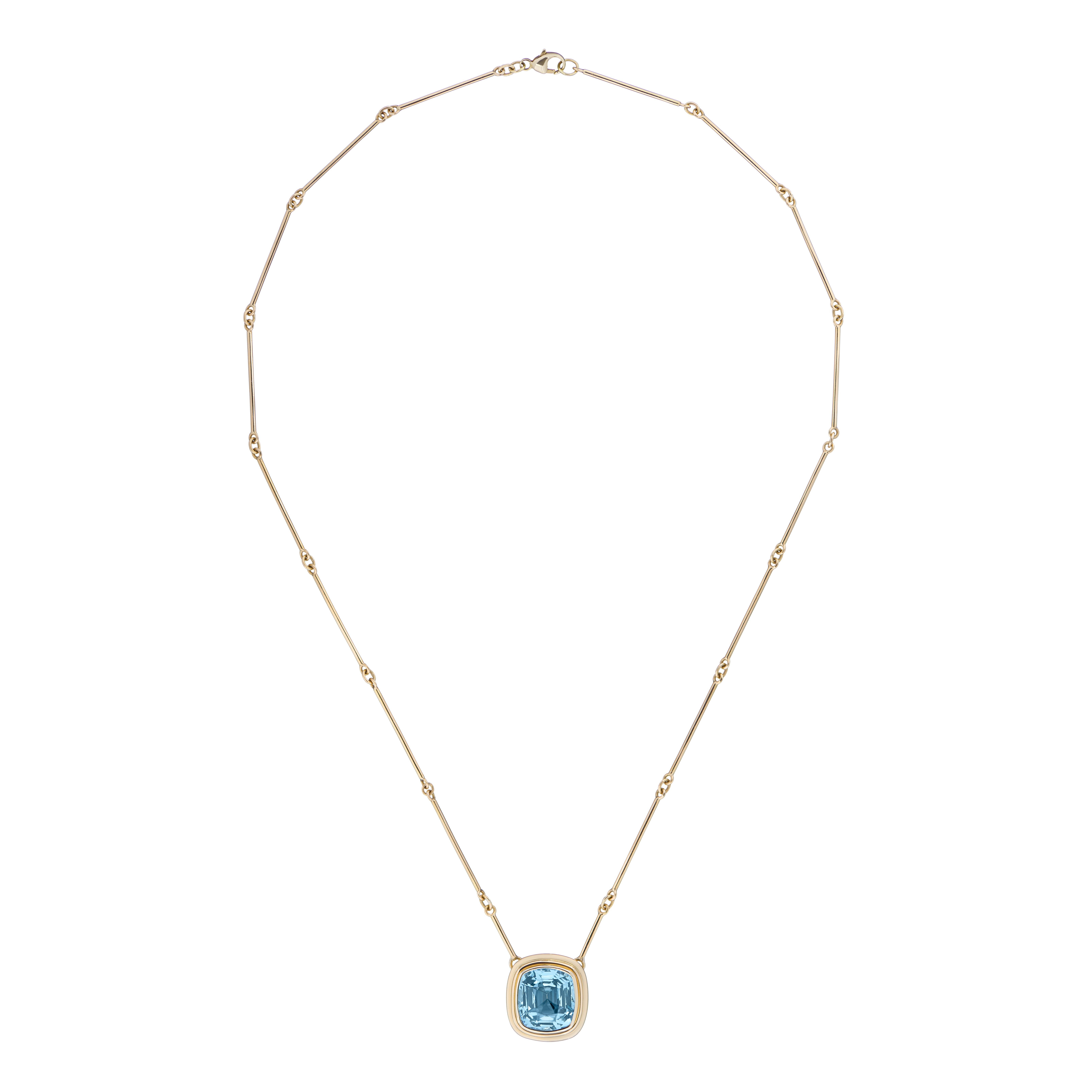 A top quality certified 6.97 carat cushion cut Aquamarine set in 18 karat yellow gold on an 18 inch gold bar chain. 
This striking statement necklace sets off any outfit. The colour of the Aquamarine is a true blue that really pops.

From the Athena