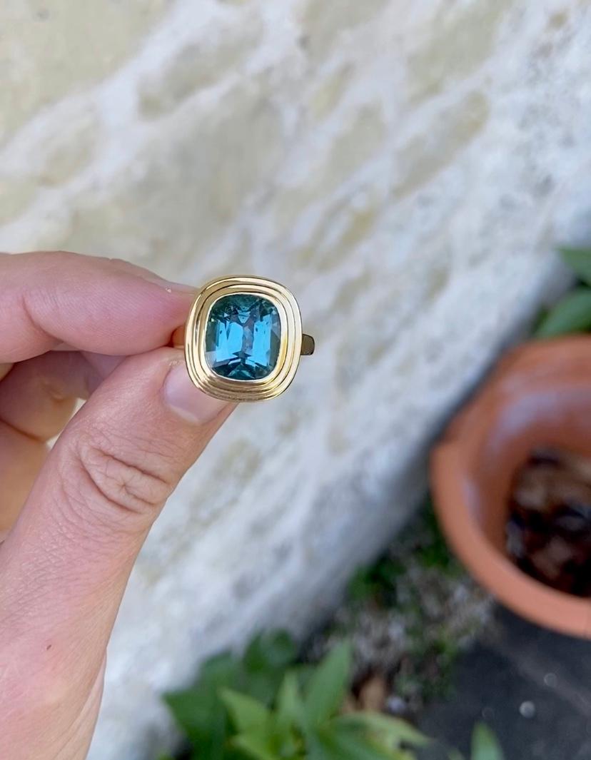 6.34 carat Blue Tourmaline ring set in 18 karat yellow gold. This beautiful blue Tourmaline is a one-of-a-kind Teal colour in a wonderful statement size, forever changing in different lights. The gemstone has a few minor natural inclusions (typical
