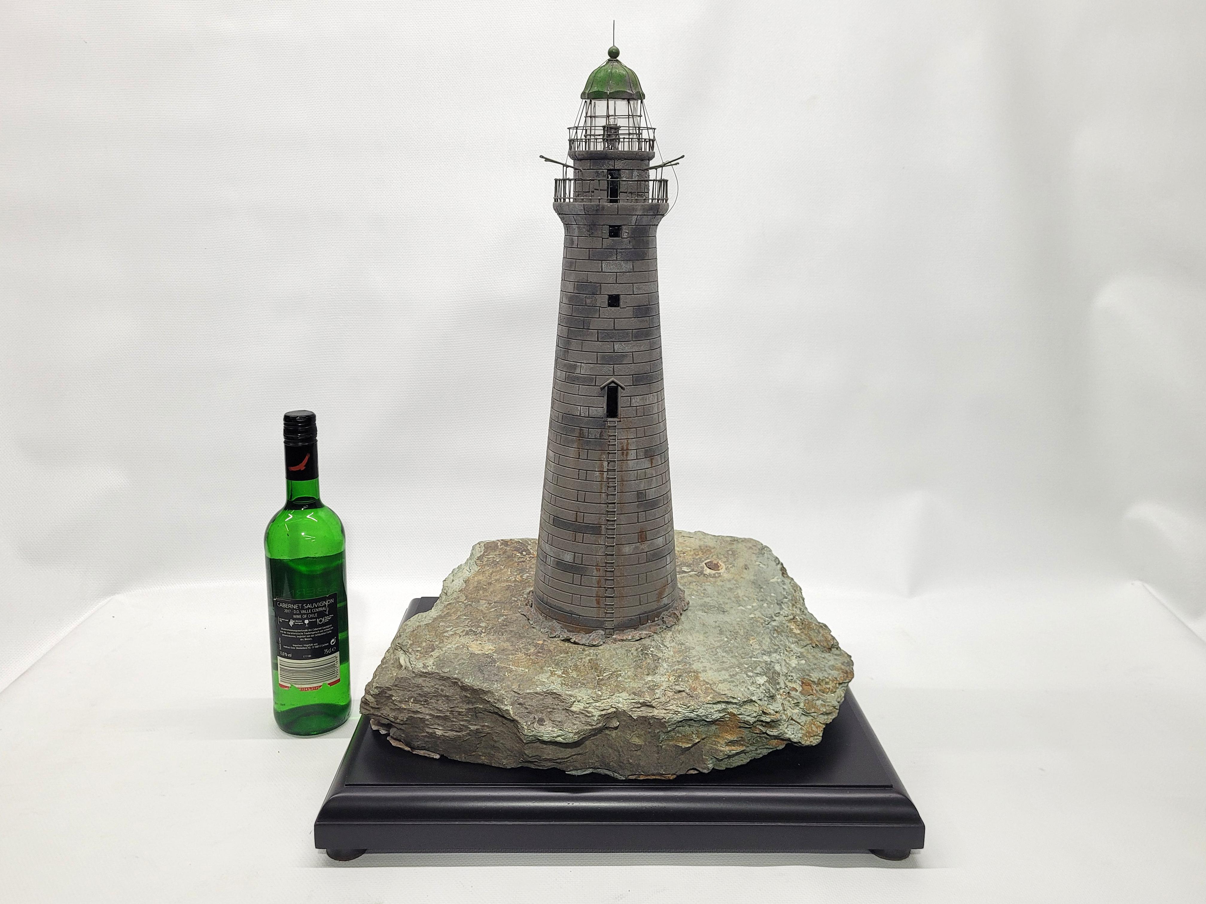 Striking model of Cohasset Minot’s ledge lighthouse. The carved tower has the accurate stone count. The light room is well done with railings and top. Mounted on a piece of ledge. Wood base also. Light flashes on and off. It does not flash