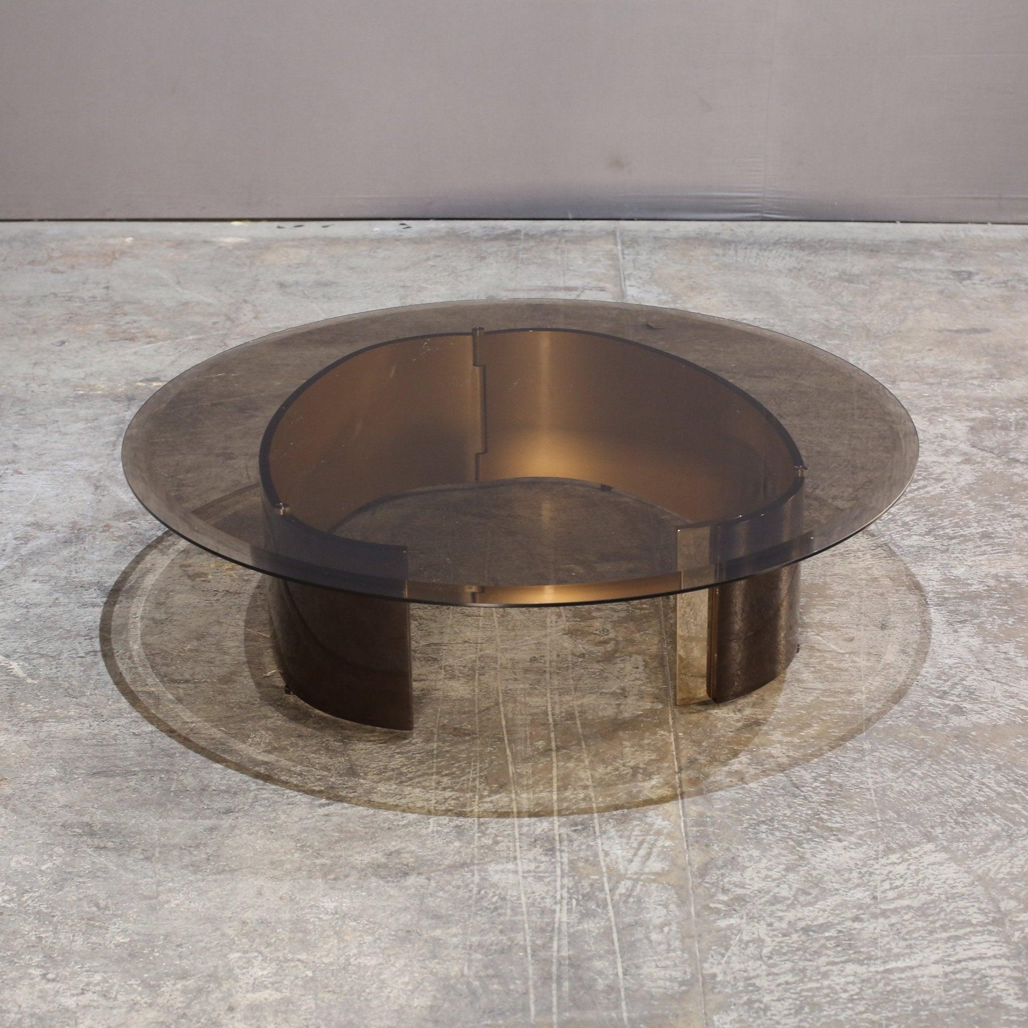 Introducing the stunning Bangle Coffee Table by renowned designer Rodolfo Dordoni for Minotti. This exquisite piece features a sleek and modern design, with a unique base crafted from polished stainless steel. Perfect for adding a touch of elegance