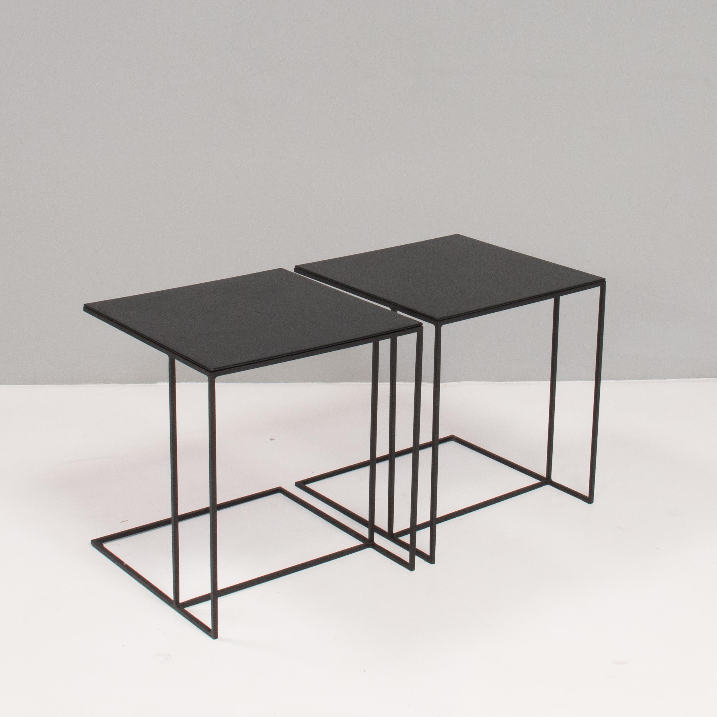 Designed by Rodolfo Dordoni for Minotti, the Ledger side table formed part of the 1998 Collection which celebrated simple, elegant shapes and linear style.

Constructed from a solid iron frame with a matt black powder coating, the side tables have