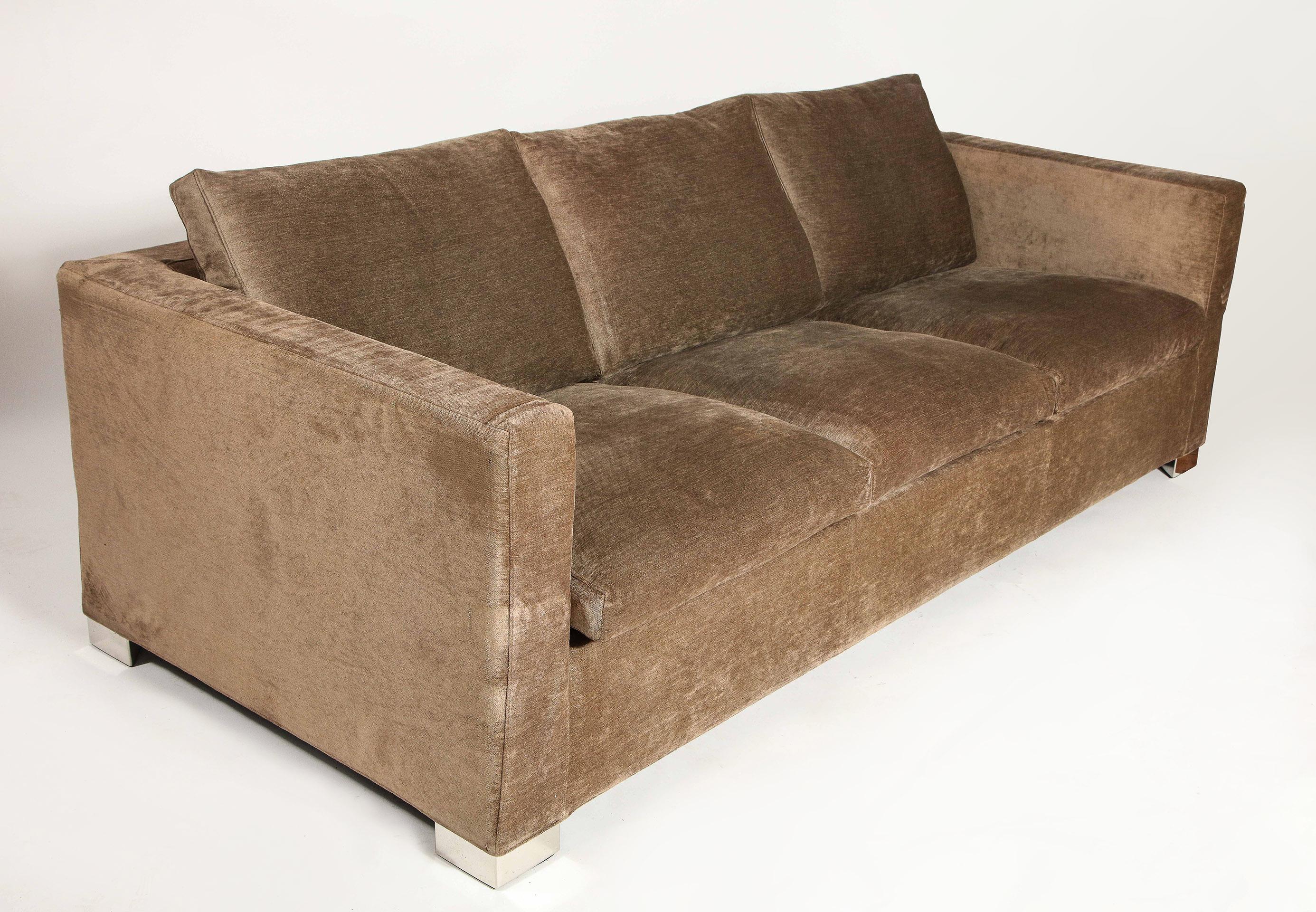 The signed three-seat sofa is of original upholstery in a textured mocha color over four chrome block feet. Sofa contains original 