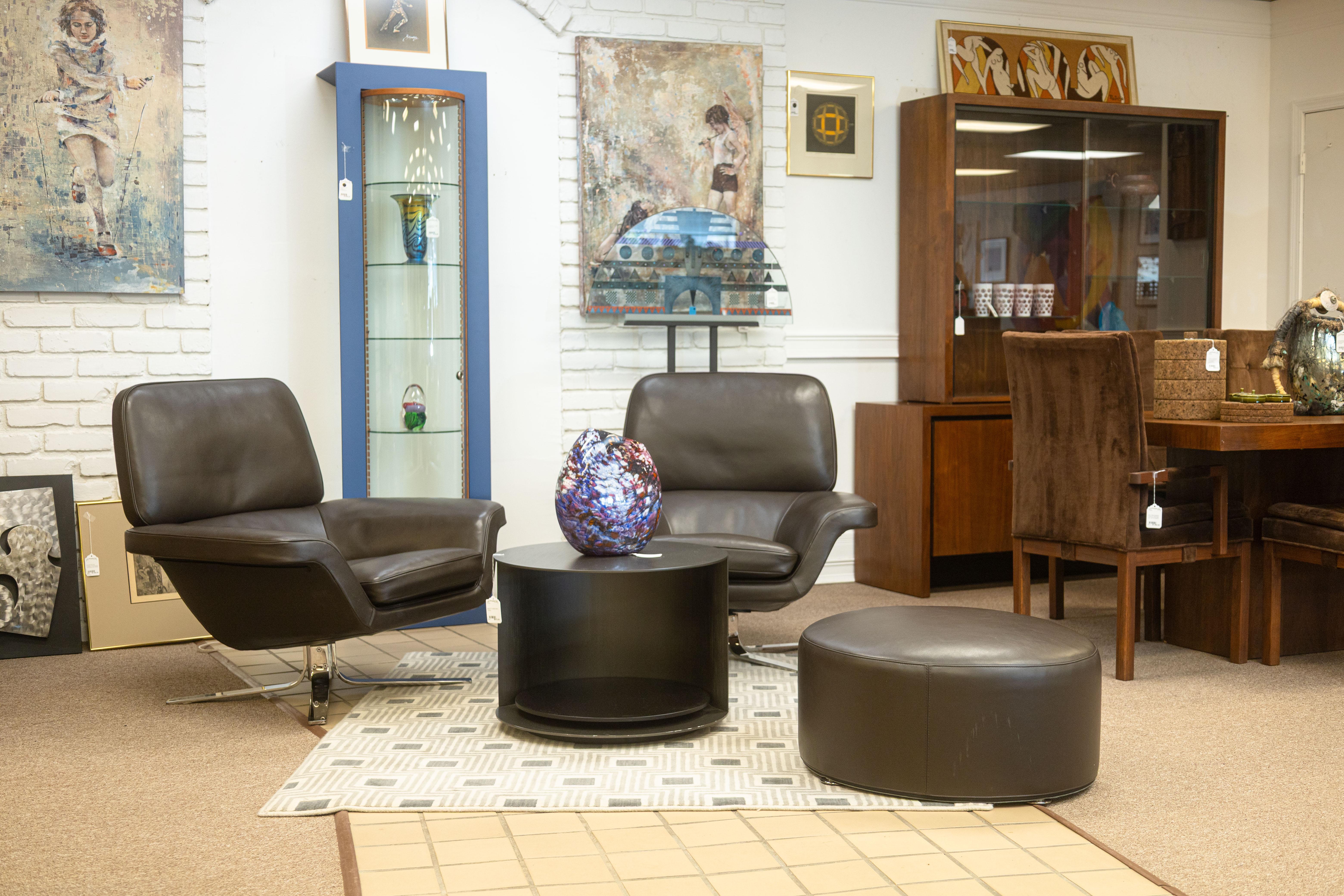 Un pouf Minotti Davis di Rodolfo Dordoni. Il pouf Davis è un piccolo e grazioso poggiapiedi contemporaneo dalla forma circolare con cuciture minime. È rivestito in morbidissima pelle marrone scuro di alta qualità e poggia su quattro piedini tondi e