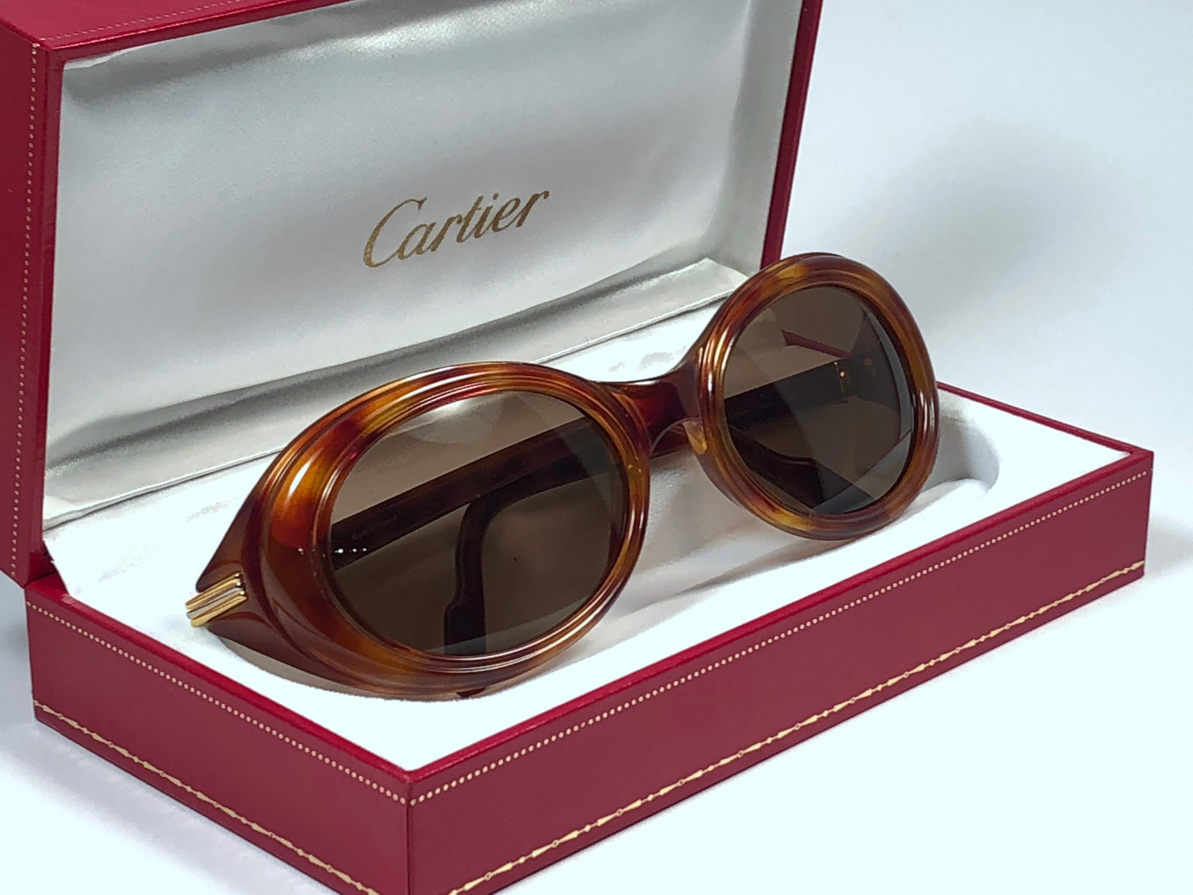 Mint Cartier Frisson in tortoise with honey brown (uv protection) lenses. 
Frame is tortoise and has the famous real gold and white gold accents. All hallmarks. 
These are like a pair of jewels on your nose with the 18k heavy gold plated accents.