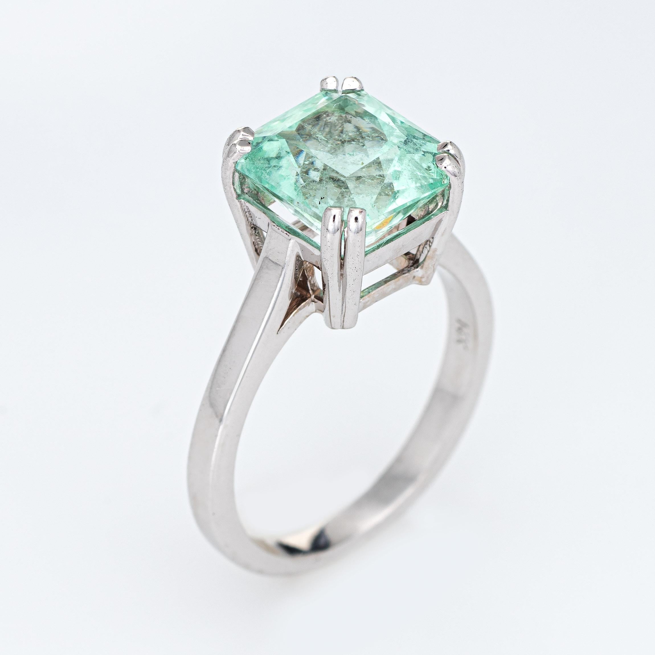 Stylish mint green emerald ring (circa 2000s) crafted in 14k white gold. 

Emerald cut emerald measures 9.5mm x 7.5mm (estimated at 4 carats). The emerald is in excellent condition and free of cracks or chips. 

The light mint green emerald is