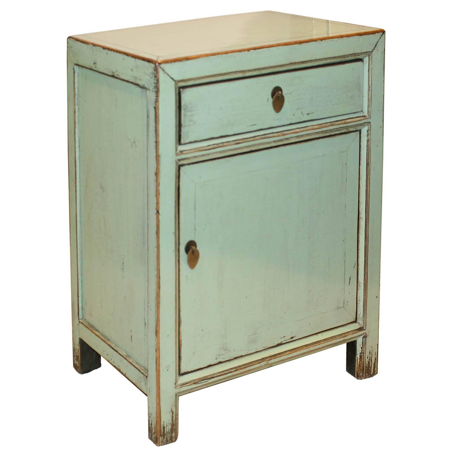 Contemporary one-drawer side chest with exposed wood edges and mint green lacquer finish will add a pop of color to a modern bedroom.