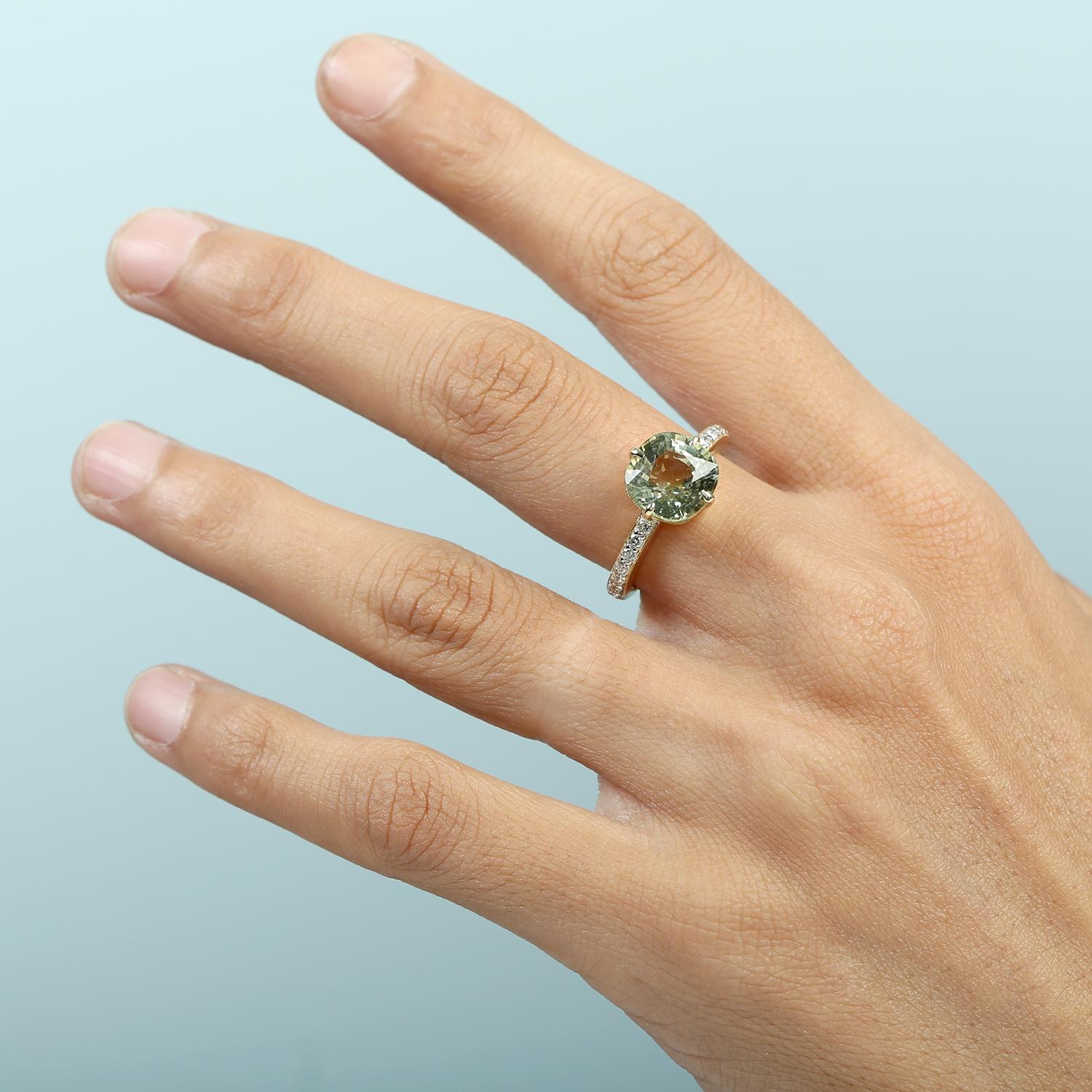 Questo anello a fascia, che rappresenta una rinfrescante rivisitazione dell'eleganza classica, è caratterizzato da una sorprendente tormalina menta come centro, completata da una linea di diamanti incastonati per un sottile scintillio. Realizzato in
