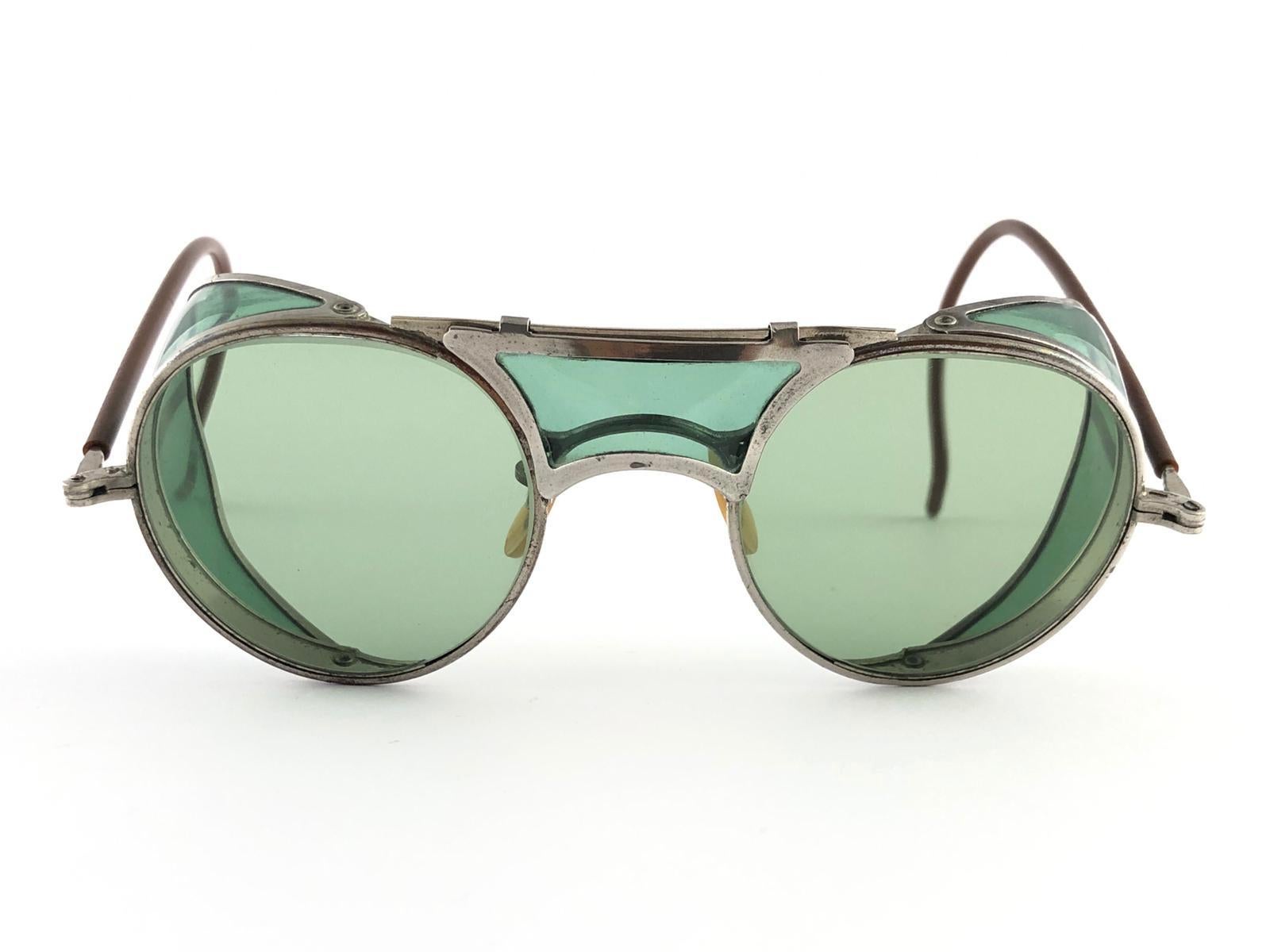 Hervorragender Artikel! 1950's Bausch & Lomb Schutzbrille.  
Klappbare grüne und silberne Metallbügel und speziell umwickelte Bügel.  Mint echte grüne runde Linsen mit leichten Verschleiß auf sie. 
Bitte beachten Sie, dass dieser Artikel fast 70