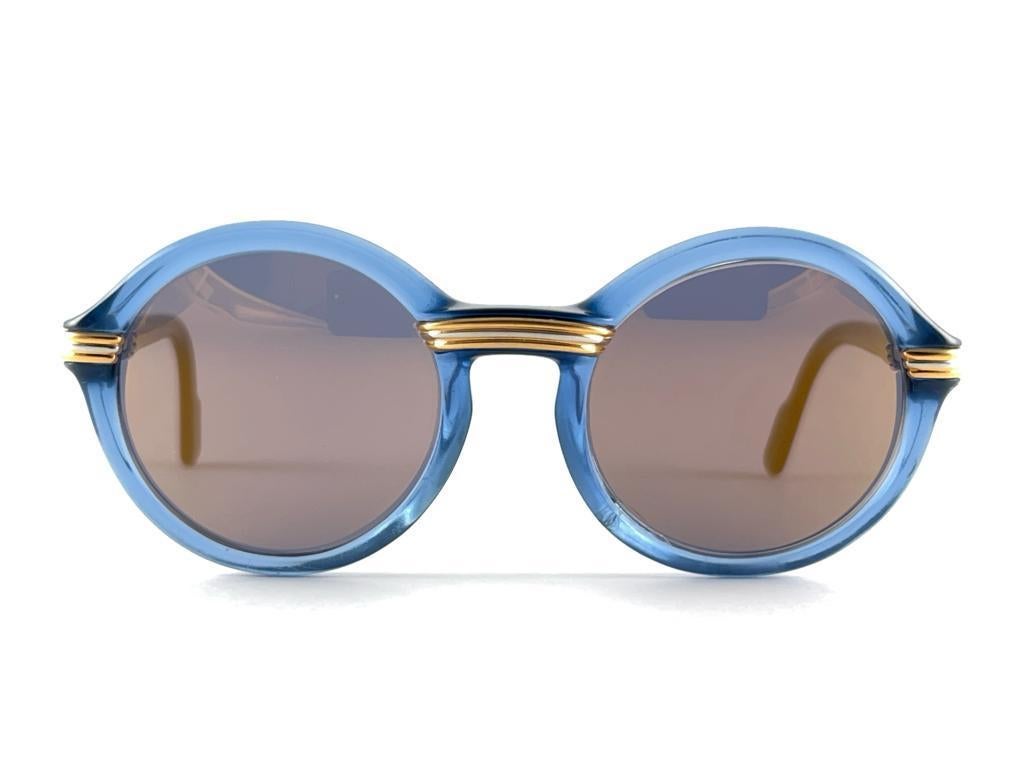 From 1991 original Cartier classy Cabriolet translucent blue edition art deco sunglasses with new gold mirror lenses (uv protection) lenses. Frame has the famous real gold and white gold accents in the middle and on the sides. 100% original. please
