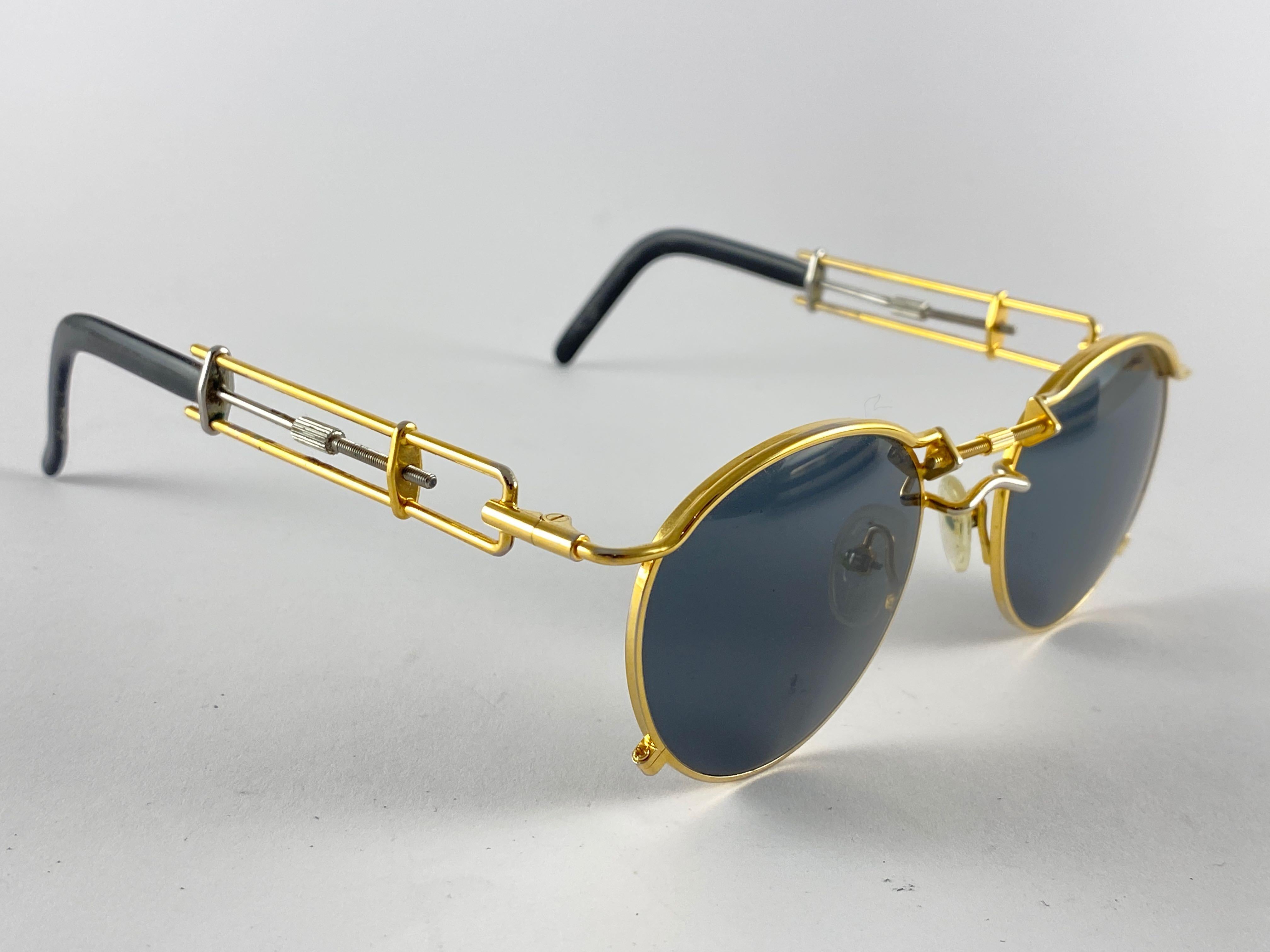 Vintage Jean Paul Gaultier 56 0174 Gold and Silver Details frame. 
Dark grey lenses that complete a ready to wear JPG look.

Amazing design with strong yet intricate details.
This item has visible sign of wear on the black acetate at the end of the