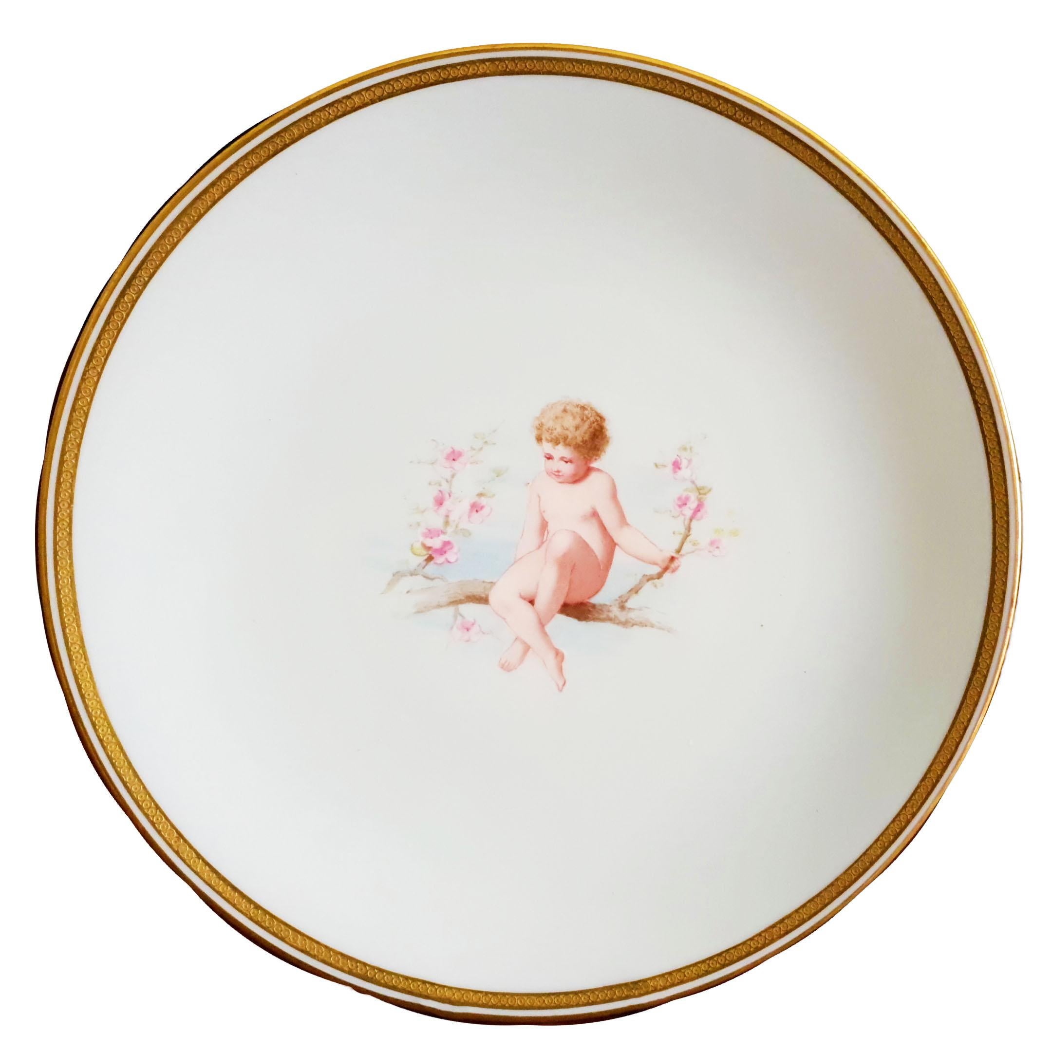 An impressive Minton cabinet plate or display plate hand painted with a cherub sitting on a flowering tree branch on a mint green ground attributed to the very famous Minton painter Antonin Hilaire Boullemier. 
A naked cherub with a full head of