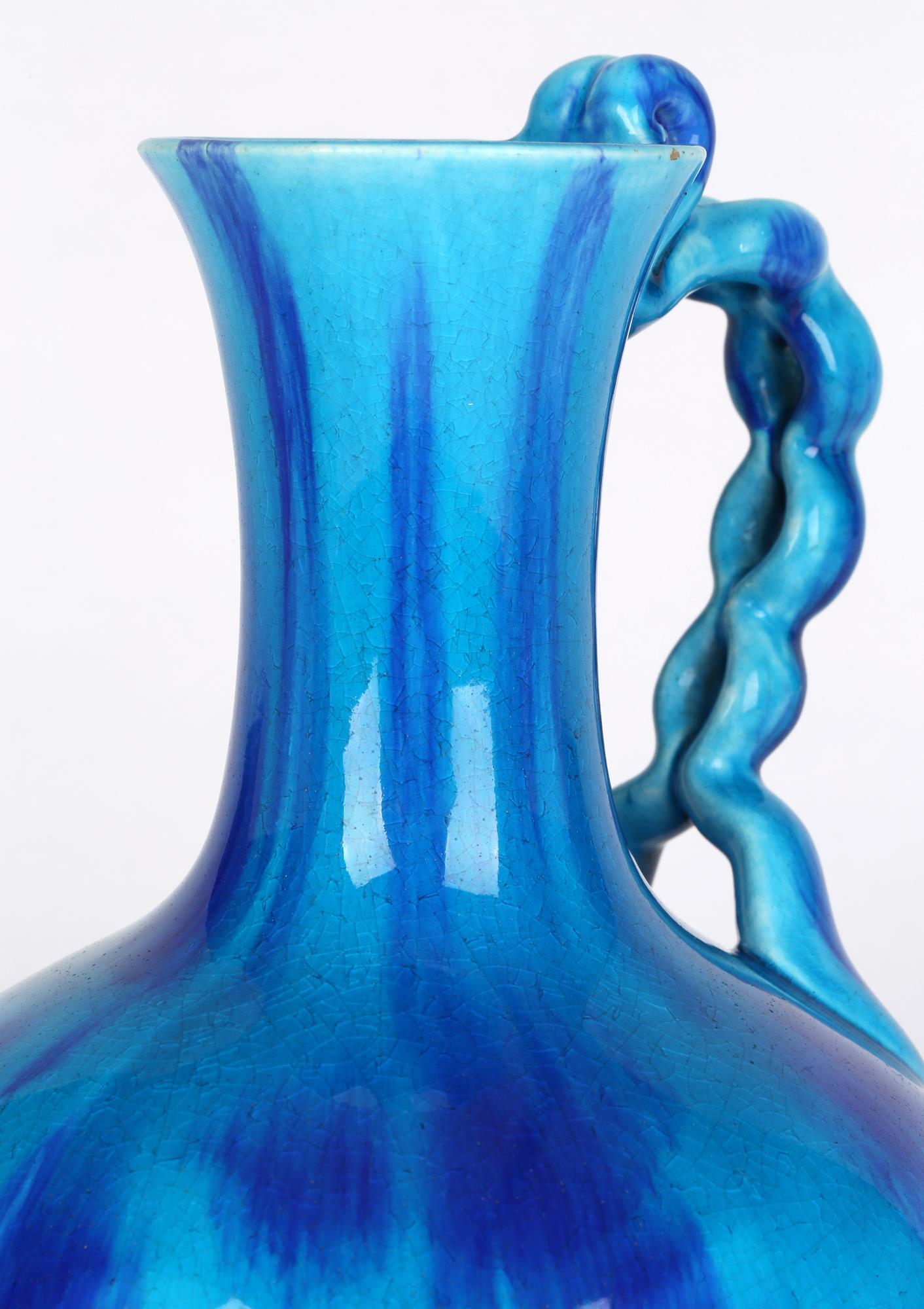 A very stylish Minton Aesthetic Movement turquoise glazed handled vase dated 1870. The earthenware vase stands on a narrow round foot with a rounded bulbous body and narrow neck with a flared top. A twin open chain style handle is applied to the