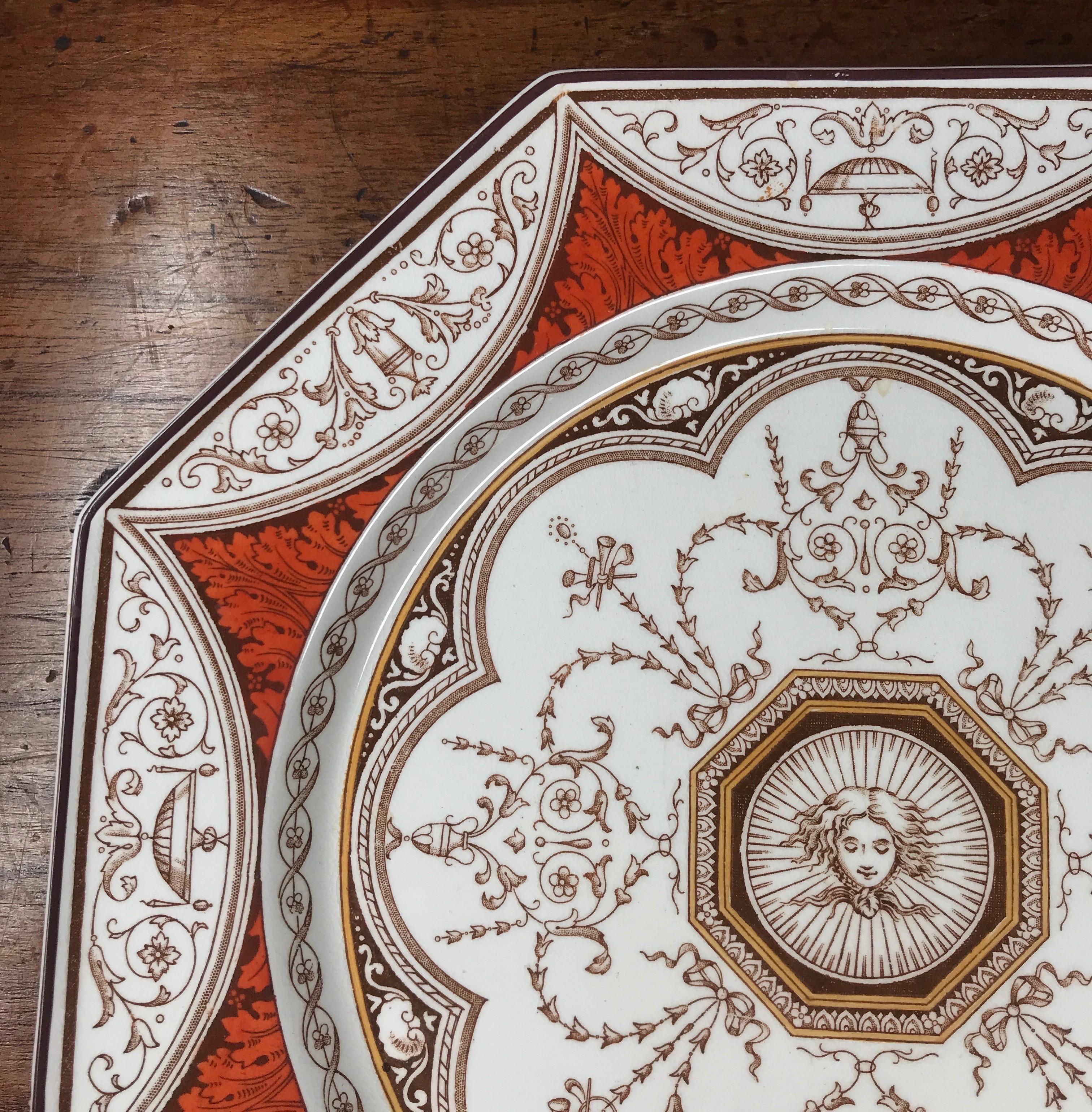 Minton octagonal plate with an intricate printed Aesthetic Movement design, comprising of a lady's face to the centre, surrounded by a neo-classical influenced border of horns and vases, acanthus leaves clobbered in orange. Pattern named on reverse